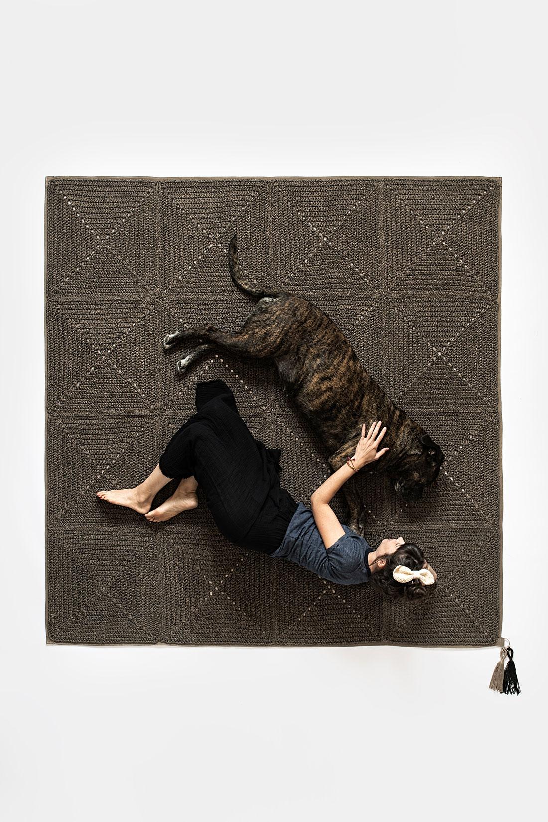 The classic crochet granny square takes a contemporary twist in this outdoor rug. Large squares form the rug, framed with bespoke webbing. Handmade from UV protected bespoke iota yarn in earth tones, the textile is soft, yet durable and suitable for