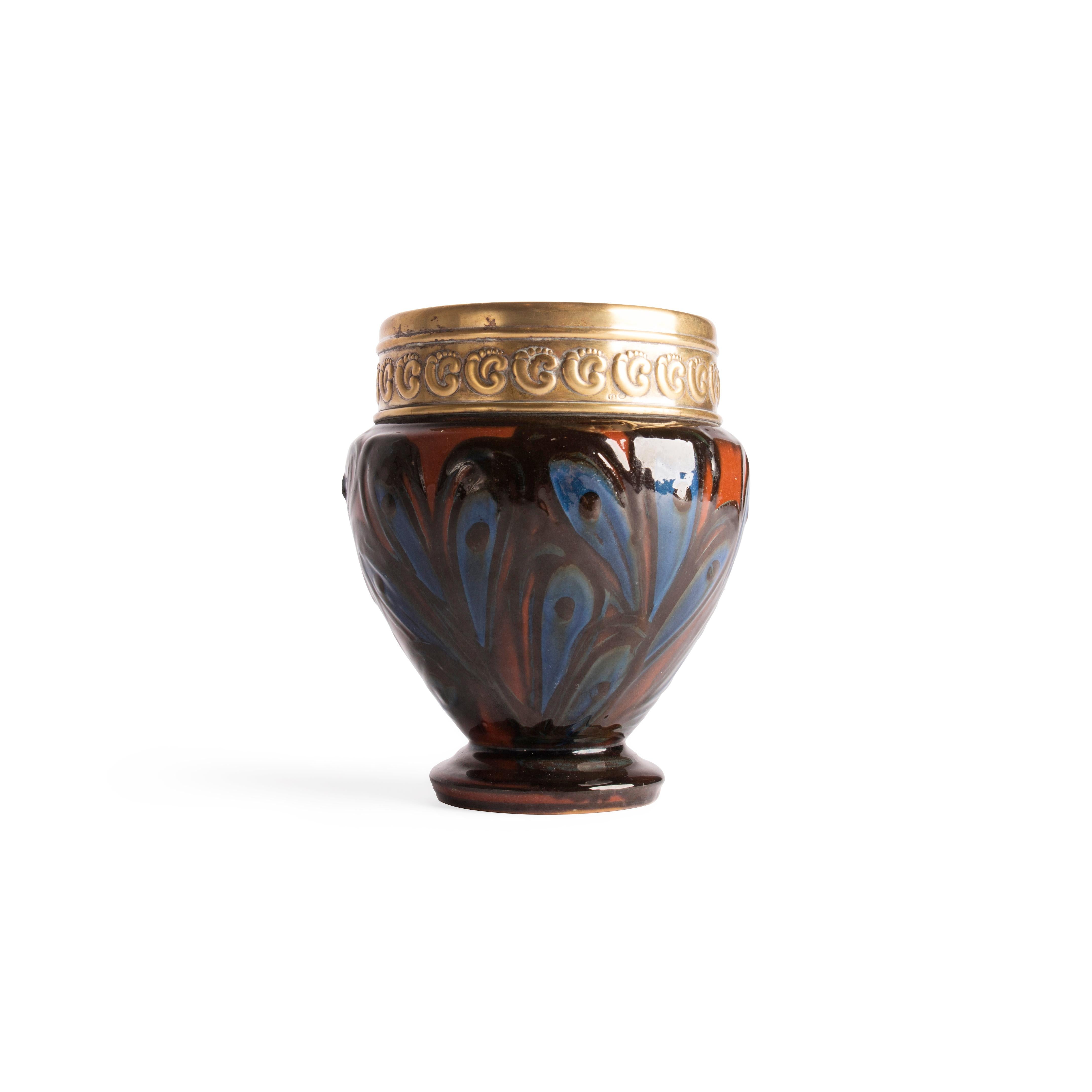 Questo importante vaso con montatura in argento placcato oro è stato disegnato da Thorvald Bindesbøll (1846-1908) ed eseguito da Herman A. Kähler, Danimarca, inizio XX secolo.

Il collo presenta ornamenti repoussé nello stile dell'artigianato
