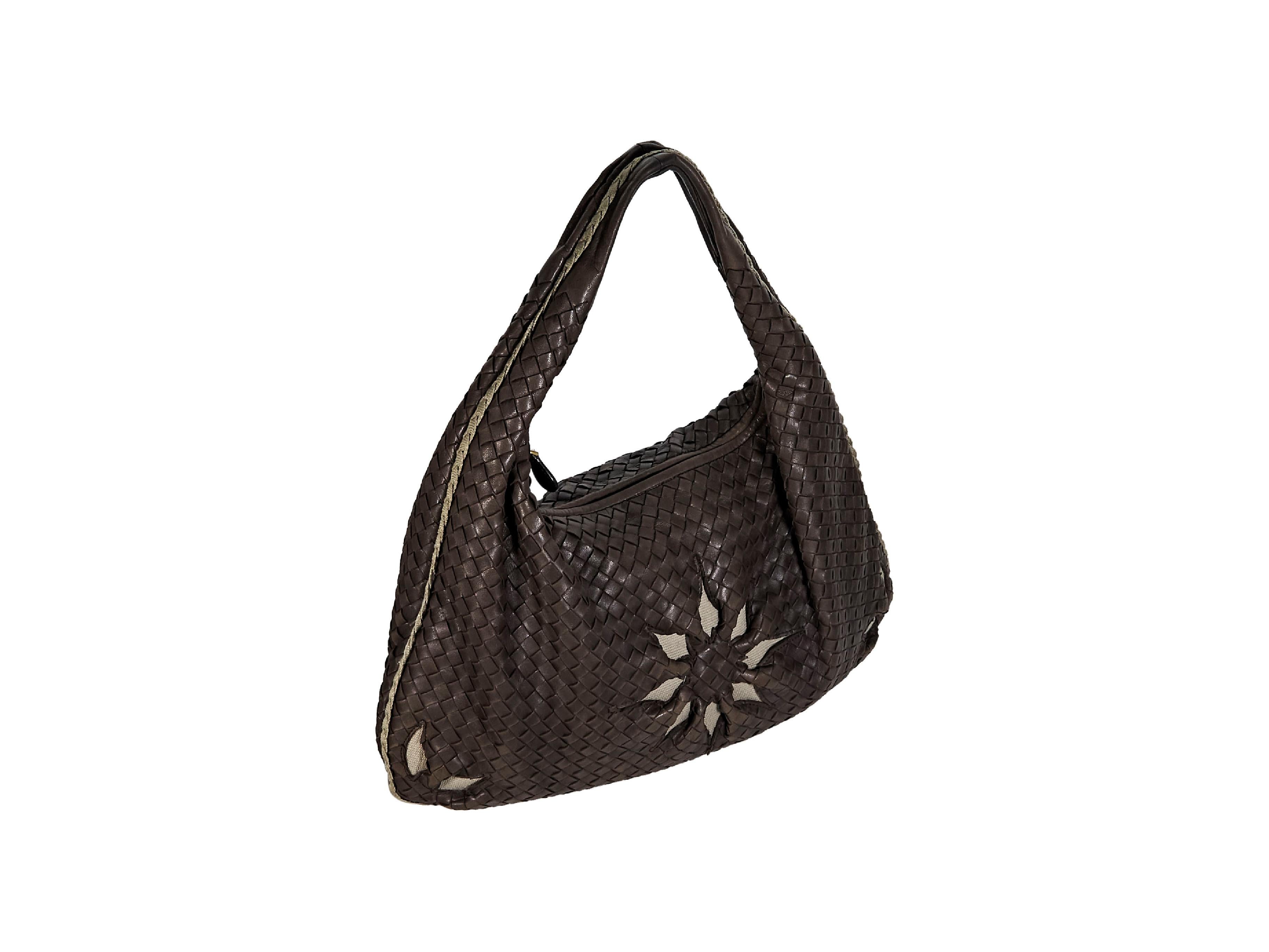Product details:  Brown intrecciato leather hobo bag by Bottega Veneta.  Floral design with peek-a-boo lining.  Single shoulder strap.  Top zip closure.  Lined interior with inner zip pocket.  Goldtone hardware.  17.5
