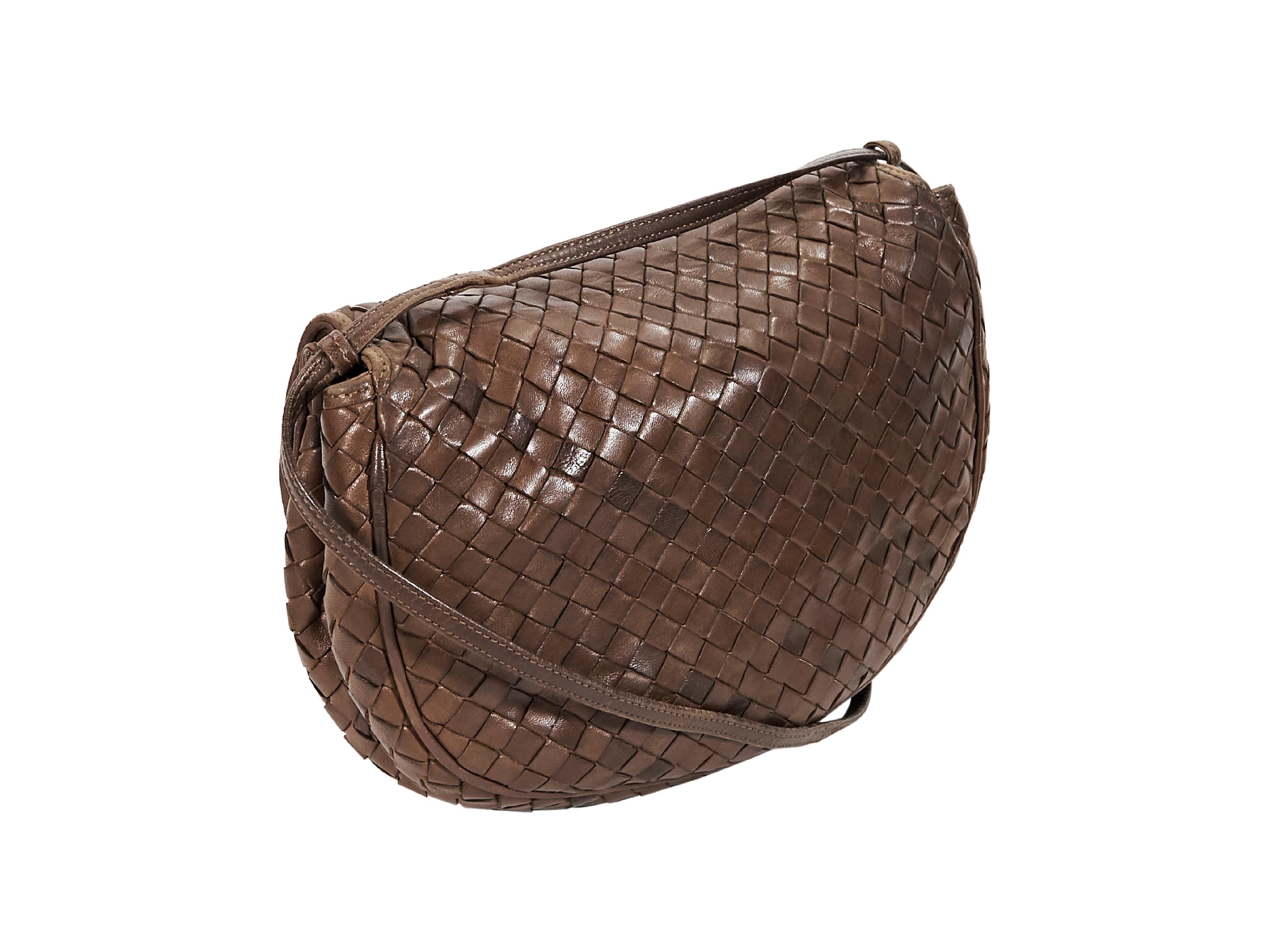 Product details:  Brown woven leather crossbody bag by Bottega Veneta.  Single crossbody strap.  Front flap accented with tassels.  Lined interior with inner zip pocket.  10