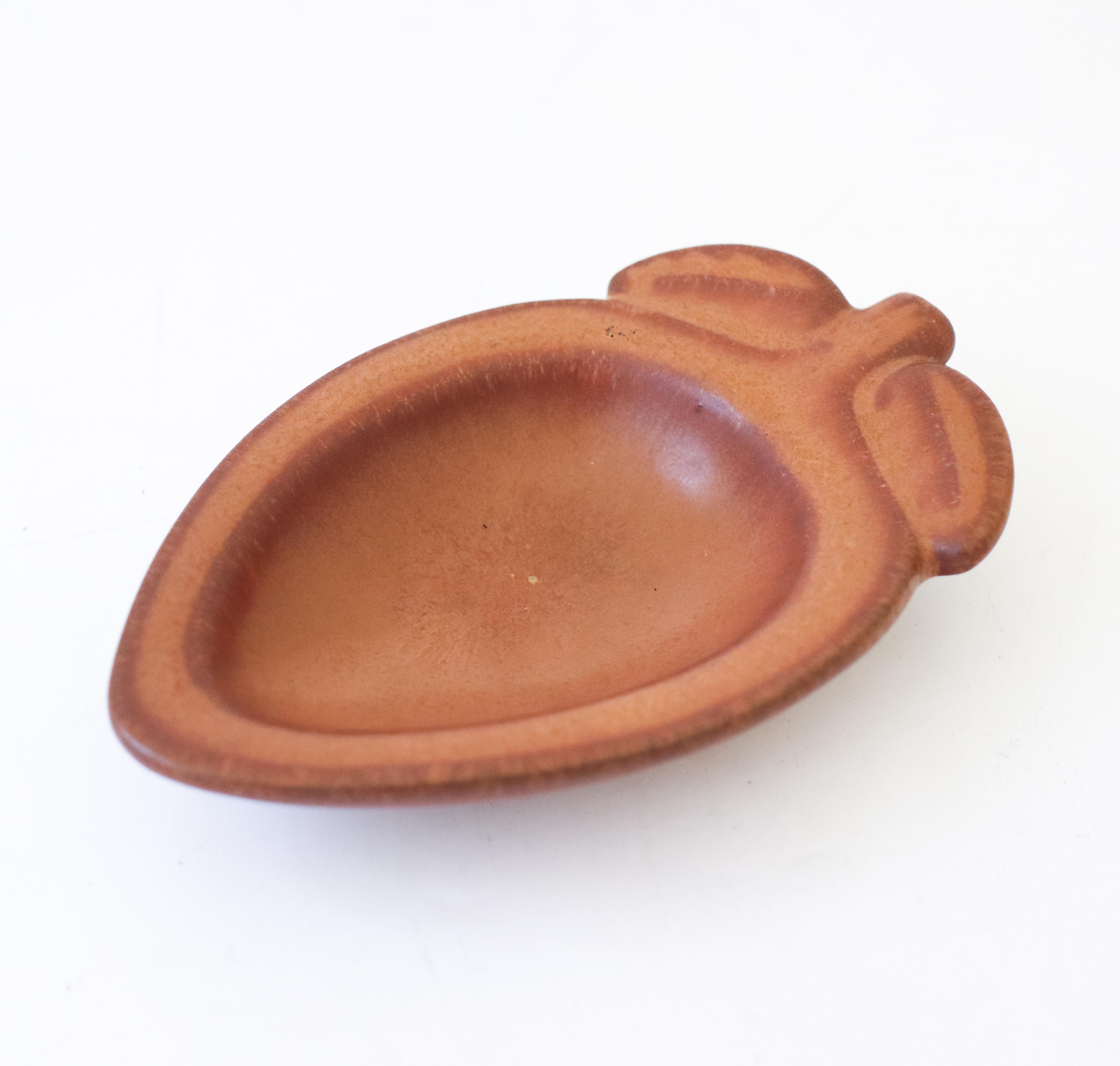 Un bol brun en forme de gland conçu par Gunnar Nylund chez Rörstrand, il mesure 13,5 x 8,5 cm de diamètre. Il est en très bon état, à l'exception de quelques petites marques. Il est marqué comme étant de 2ème qualité. 

Gunnar Nylund est né à Paris