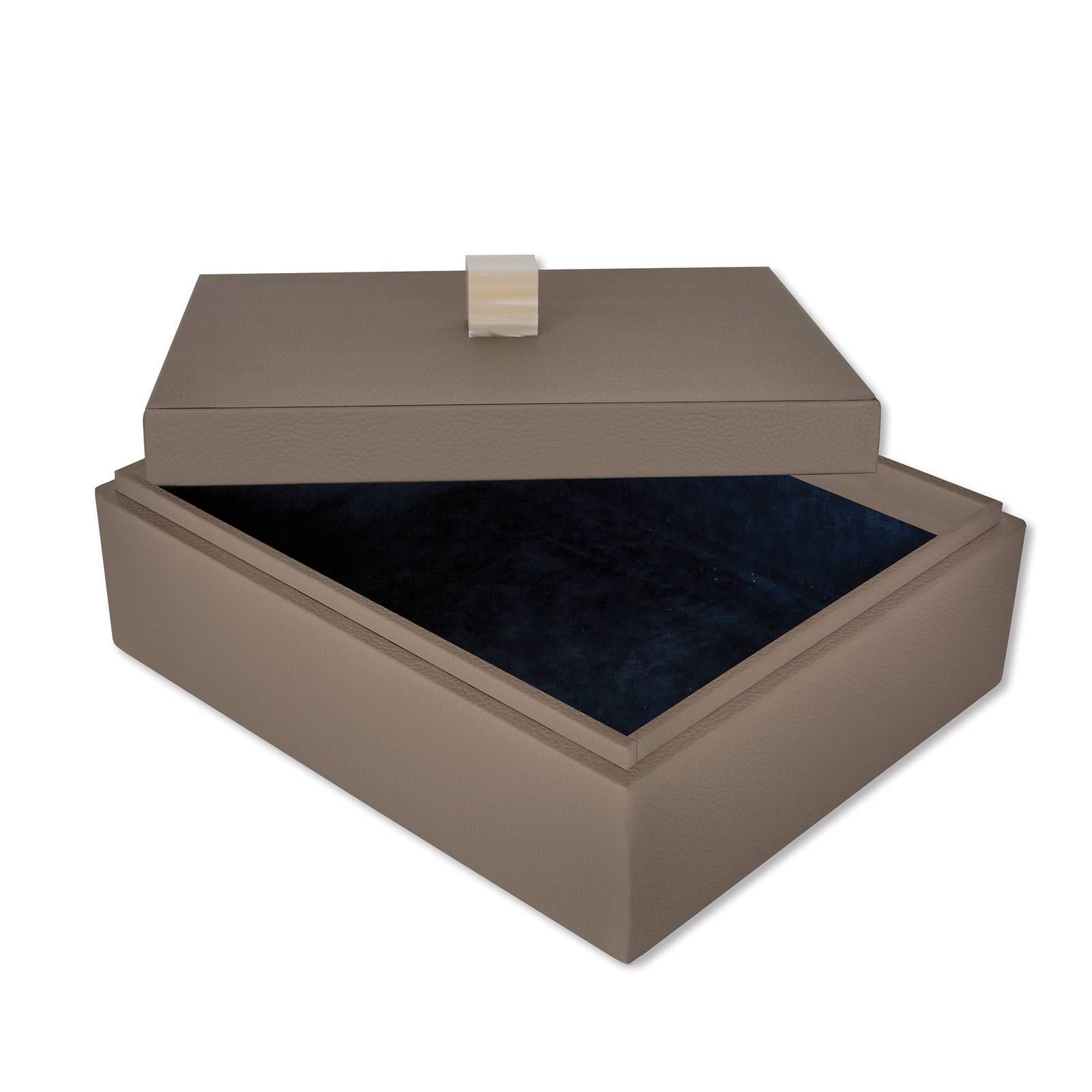 Versatile and sophisticated, this elegant box is a precious addition to any modern or contemporary home. Crafted of wood, its rectangular silhouette and lid are covered by hand with brown fine grain leather. Available in five different colors, this