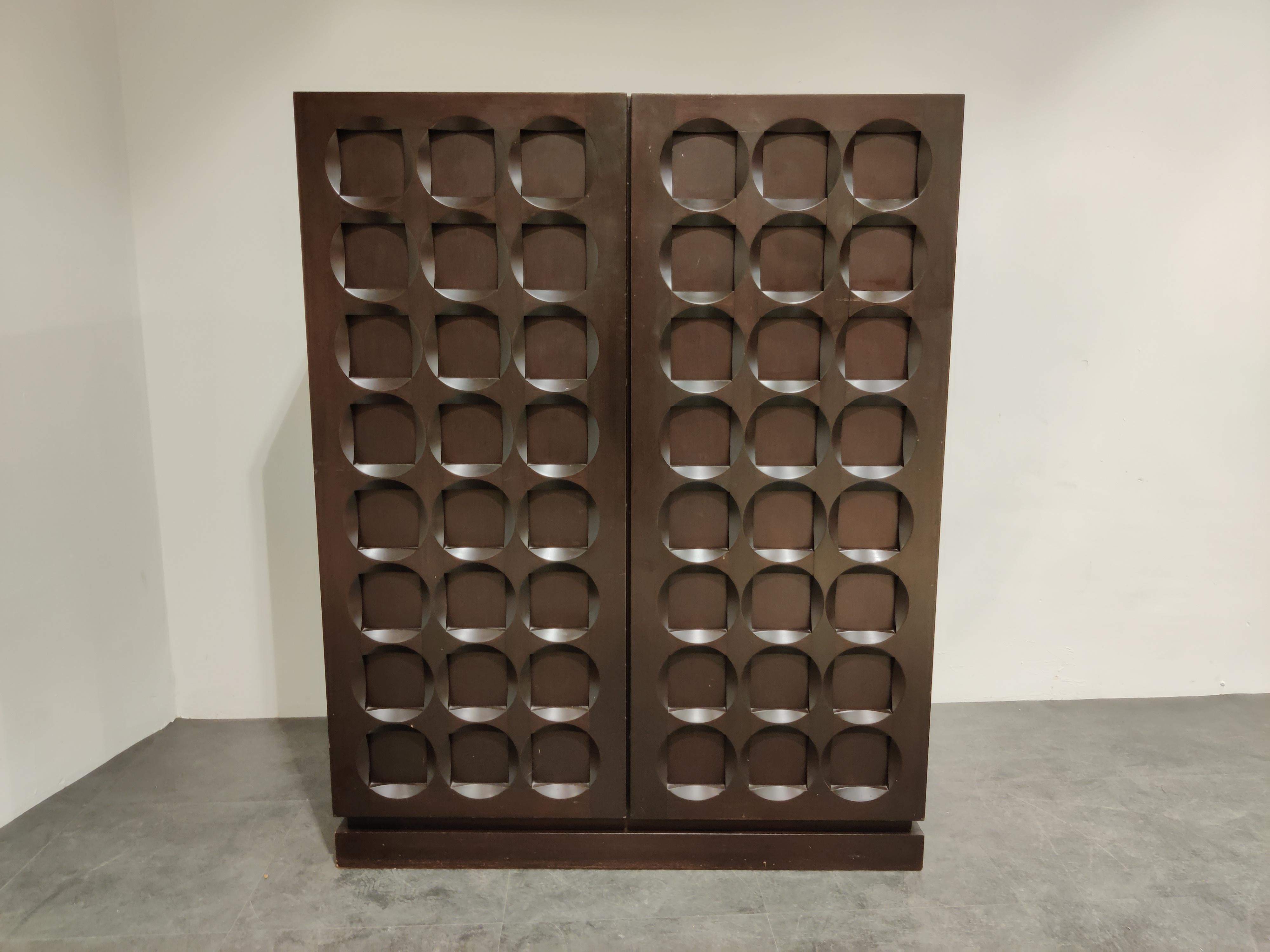 Beautiful brown wooden Brutalist bar cabinet.

Stunning graphical design doors.

Contains a built in bottle holder.

Eye catching and timeless piece.

Good condition.

1970s, Belgium

Dimensions:
Height 141cm/55.51