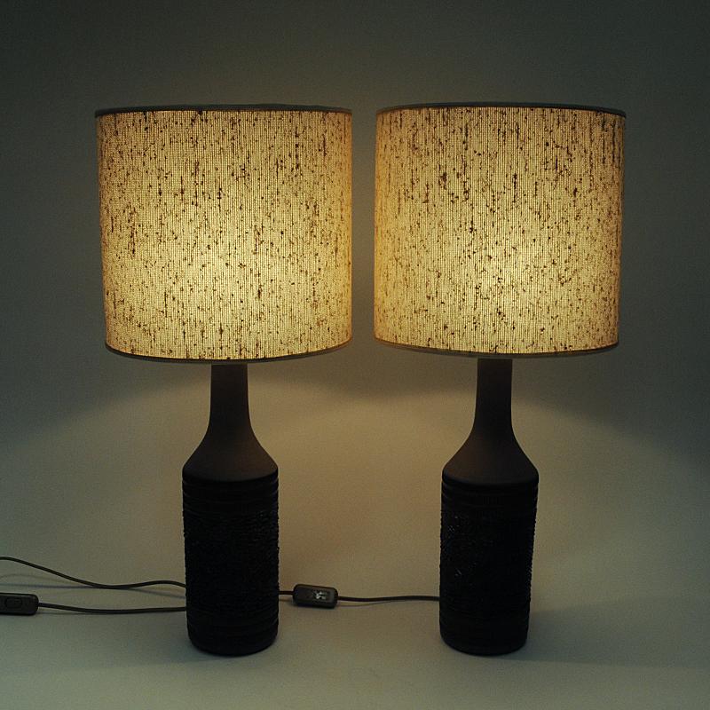 A special pair of ceramic table lamps made by Nila Keramik Alingsås, Sweden 1970s. Bottle shaped design with dark brown earth colors and a matt finnish. Perfect in every room both as a pair or placed alone. Handmade with rough relieff patterns in