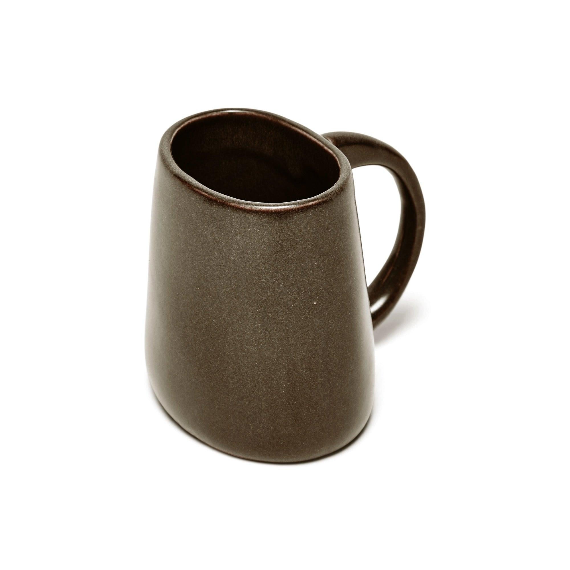 Mug en céramique de forme ovale avec poignée. Finition avec une glaçure brune.