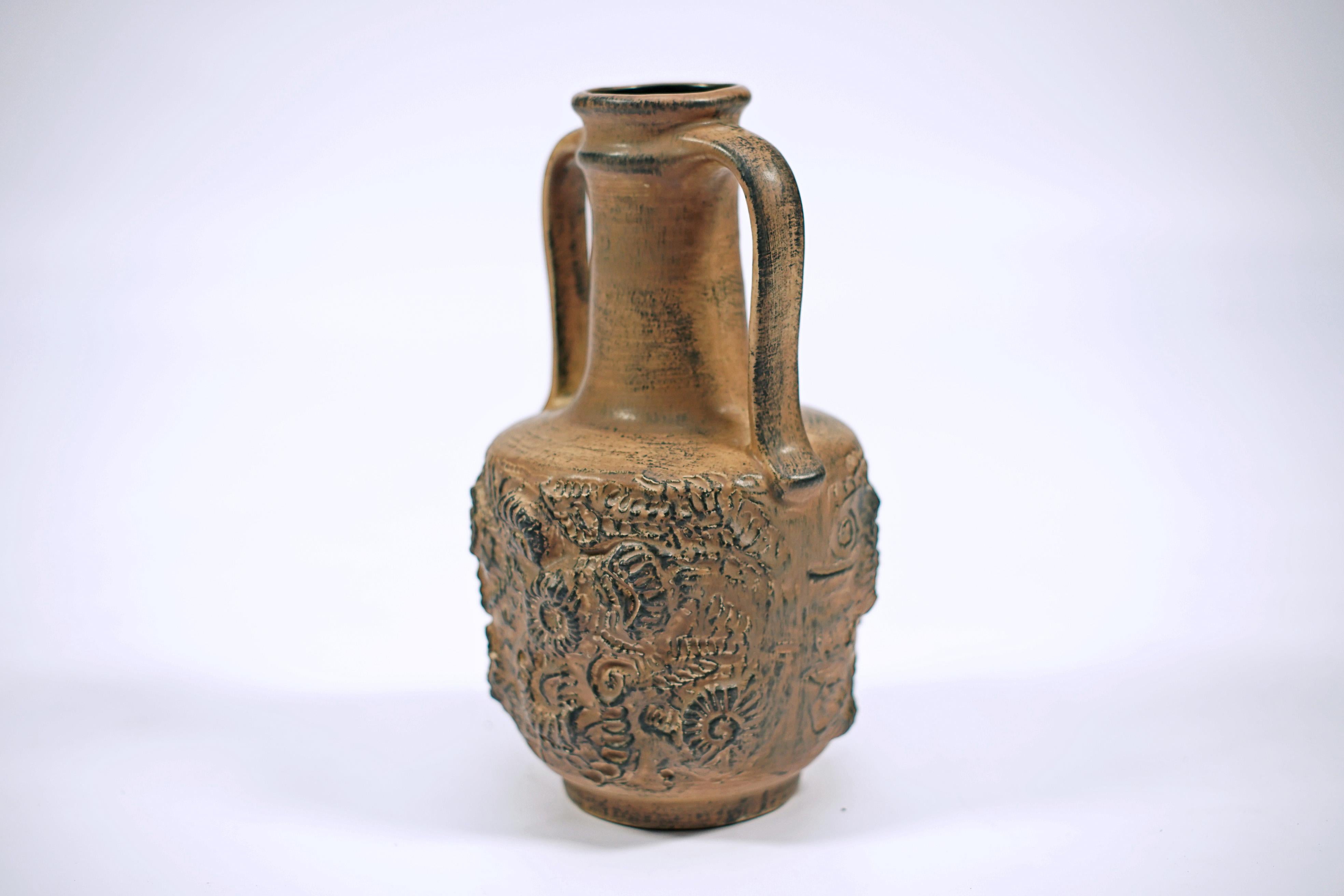 Vase à anses en céramique brune, avec un motif d'escargots fossilisés. Par CARSTENS-TÖNNIESHOF (1946 - 1977).

En 1892, les frères Christian et Ernst Carstens ont ouvert une usine de céramique à Brandebourg, en Allemagne de l'Est. En 1945,