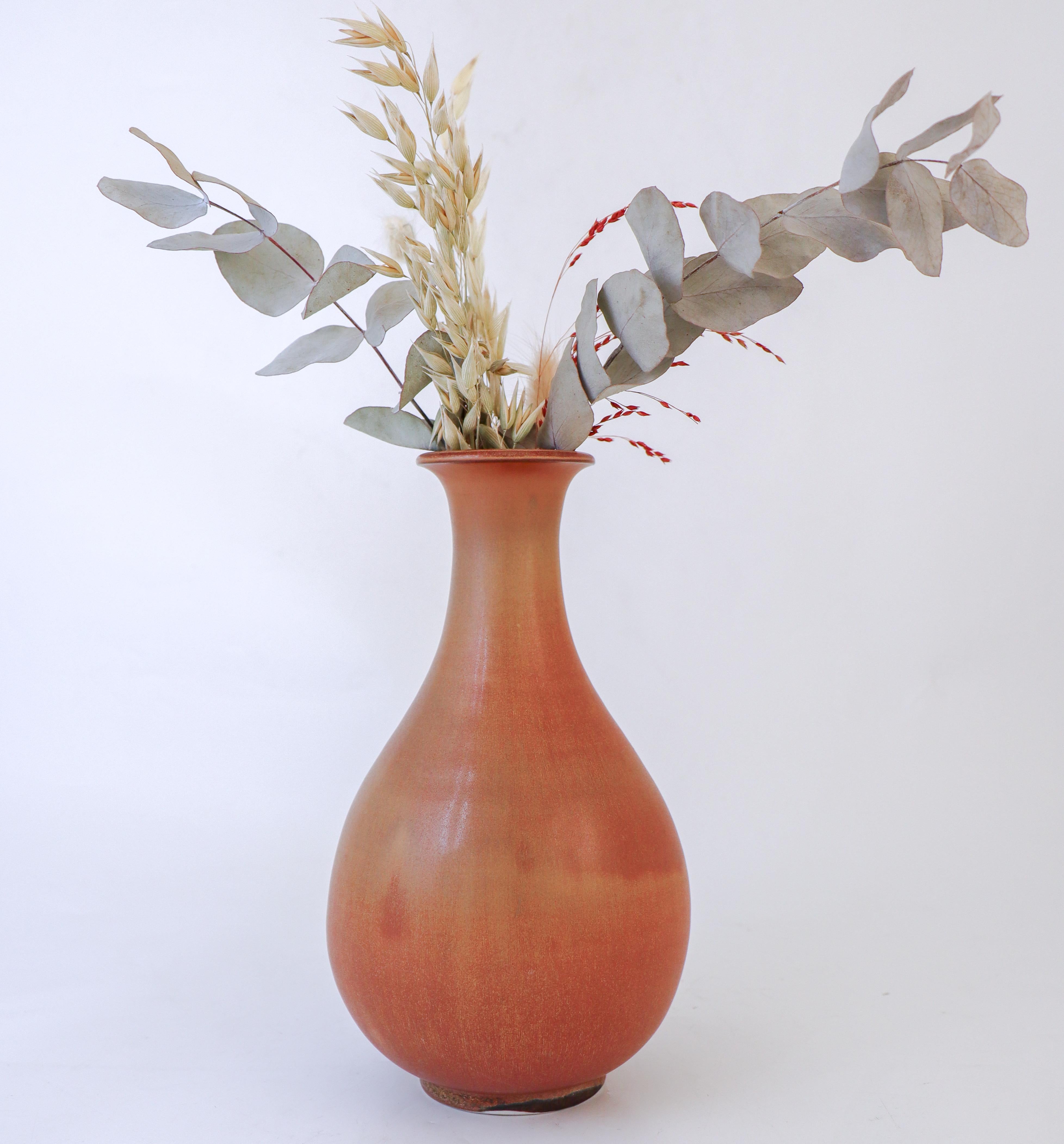 Il vaso in ceramica marrone, disegnato da Gunnar Nylund a Rörstrand, misura 23 cm di altezza e 13 cm di diametro. È in condizioni eccellenti, tranne che per un piccolo problema di vetratura vicino alla base, per cui è contrassegnato come seconda