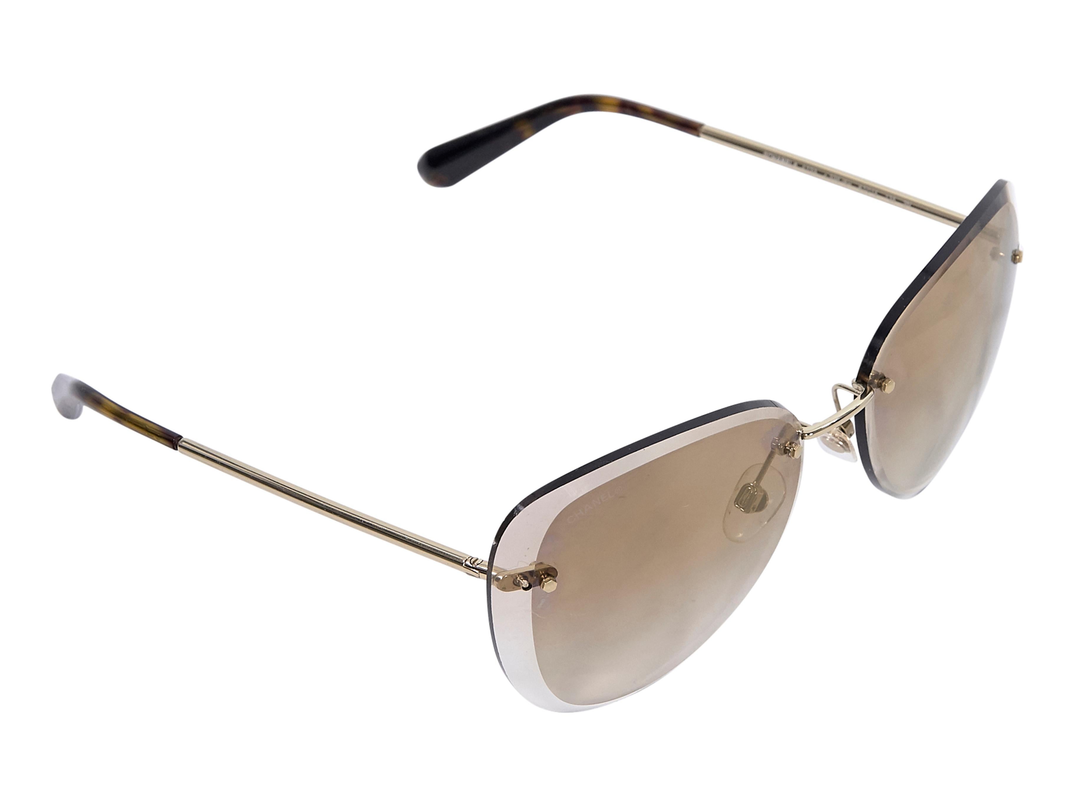 Product details:  Brown cat-eye sunglasses by Chanel.  Gradient lenses.  Cushioned nose pads.  Goldtone hardware.  2.75