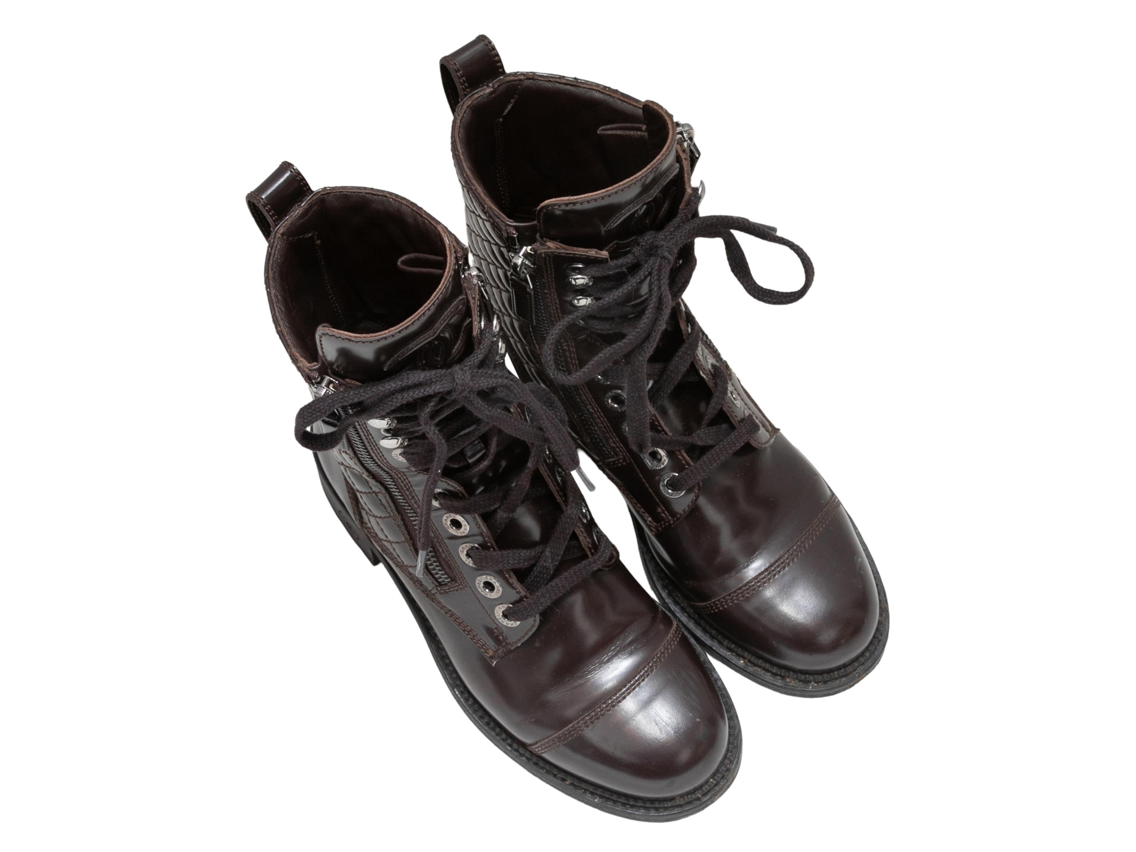 Brown quilted patent leather combat boots by Chanel. Silver-tone hardware. Lace-up tie detailing at tops. Zip closures at sides. 6