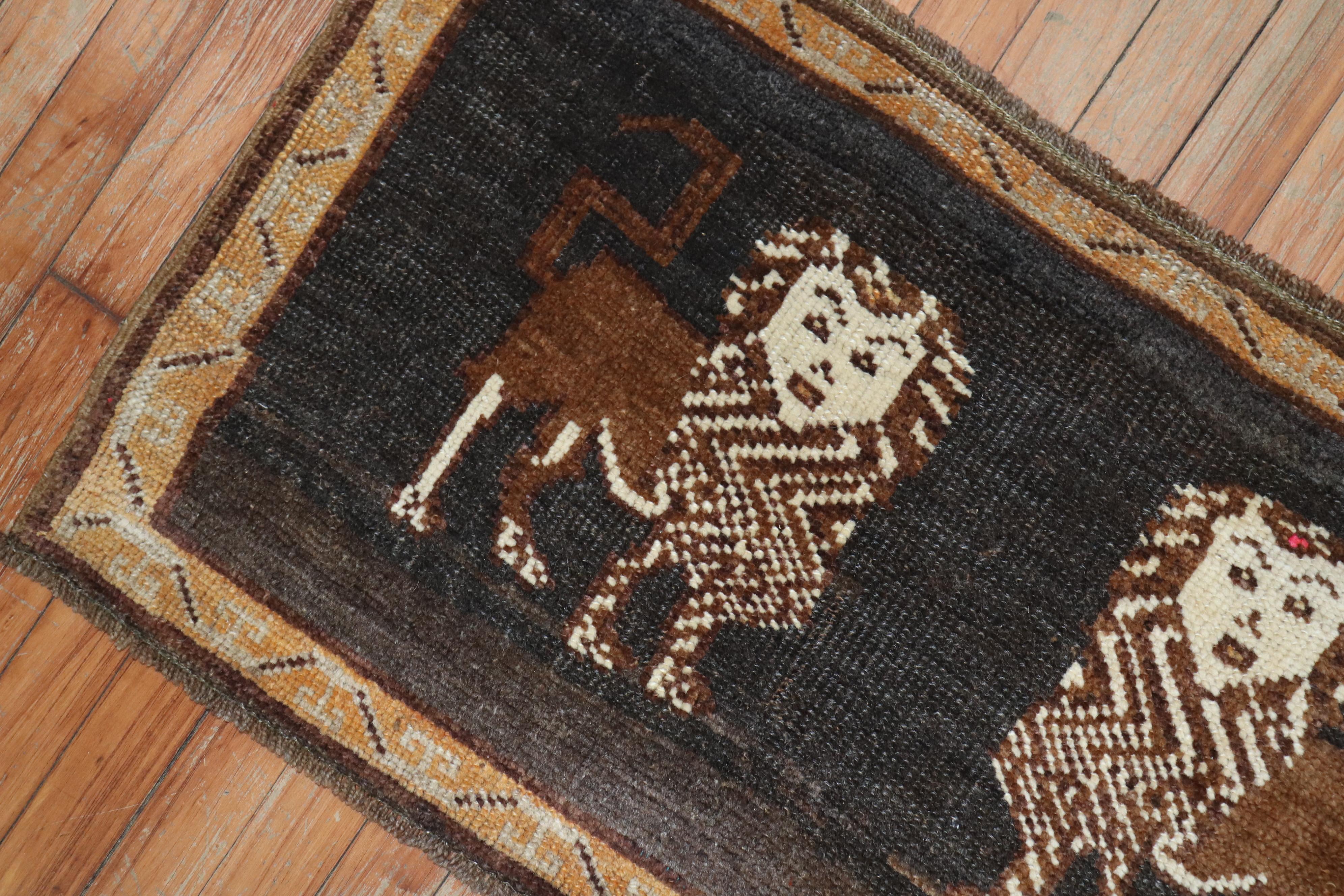 A mid 20th century Turkish rug depicting 2 brown lions on a black/charcoal colored ground.

Measures: 1'10