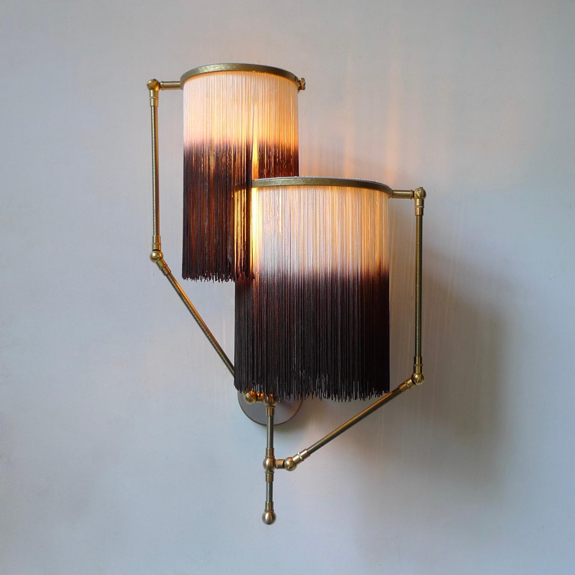 Brown charme sconce lamp, Sander Bottinga

Dimensions: 50 x W 38 x D 27 cm
Handmade in brass, leather, wood and dip dyed colored Fringes in viscose.
The movable arms makes it possible to move the circles with fringes in different positions.
So