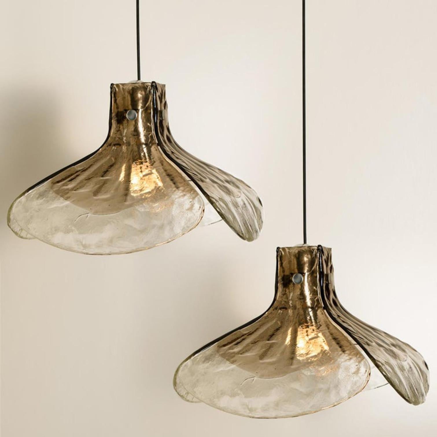 1 of the 2 pendant lamps, model LS185 by Carlo Nason for Mazzega.
Four crystal clear and smoked brown leaves compose this beautiful handmade piece of thick Murano glass.

Measures: H 16.93” (43 cm), D 23.62