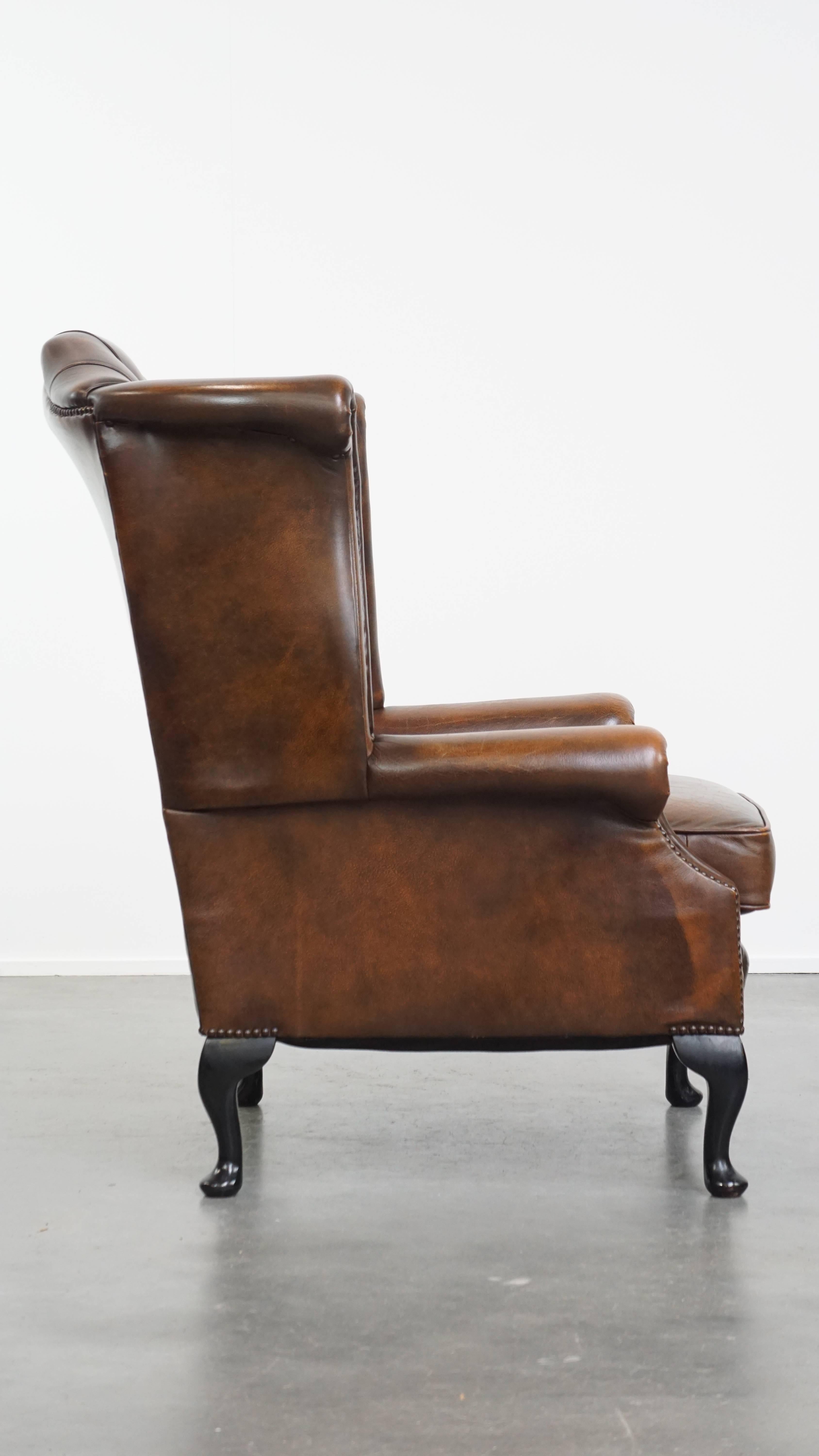 Offert ici ce fauteuil classique Chesterfield à oreilles en cuir de vachette brun cognac, bien conservé, de style anglais.

Ce fauteuil à oreilles en cuir est le complément idéal pour les amateurs de mobilier Chesterfield. Sa belle couleur brune et