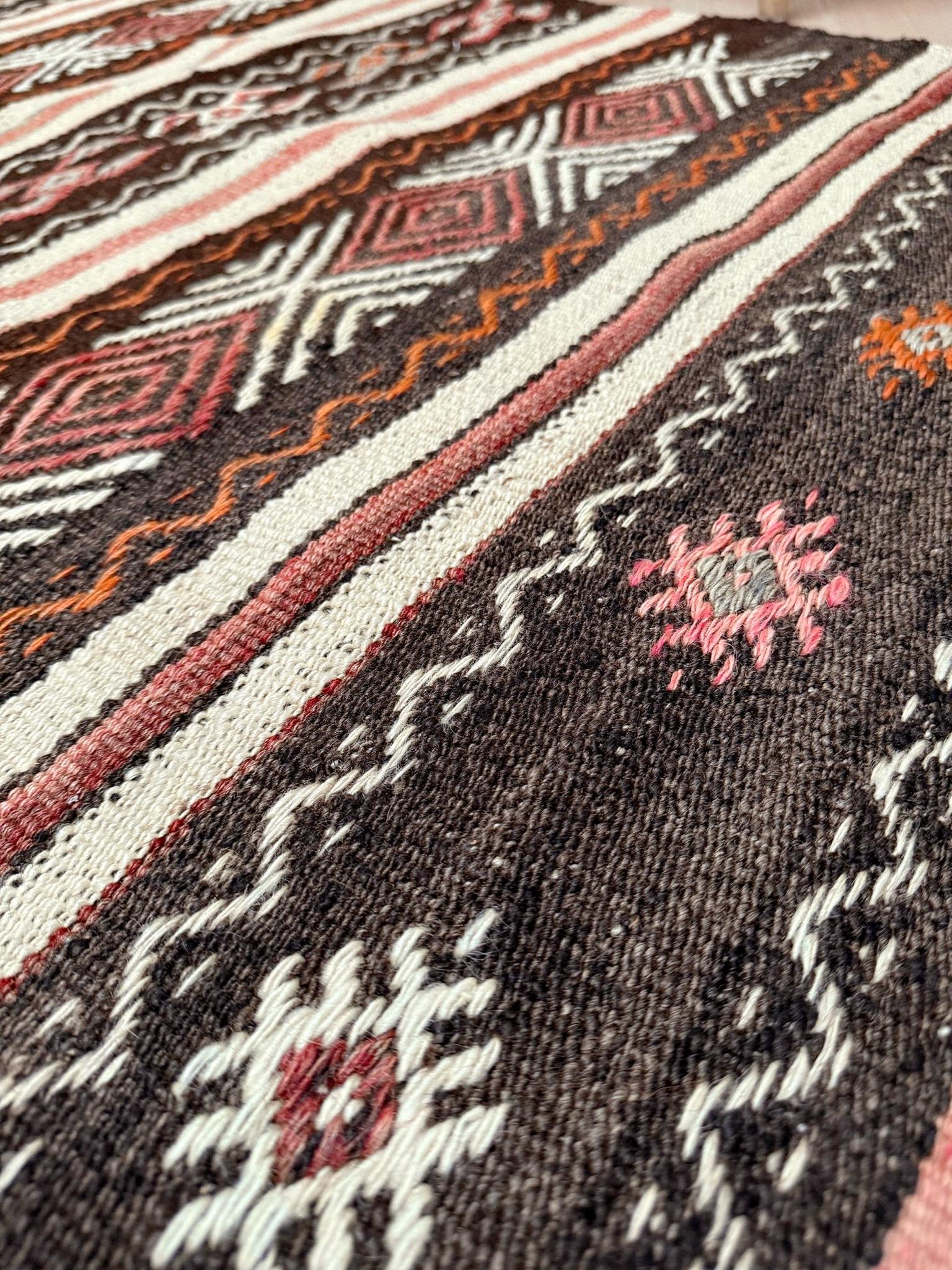  Ce kilim vintage de l'est de la Turquie présente la technique distinctive de broderie en relief connue sous le nom de cicim, où des fils de trame supplémentaires sont enroulés sur la surface pour créer une texture et des détails géométriques. Tissé
