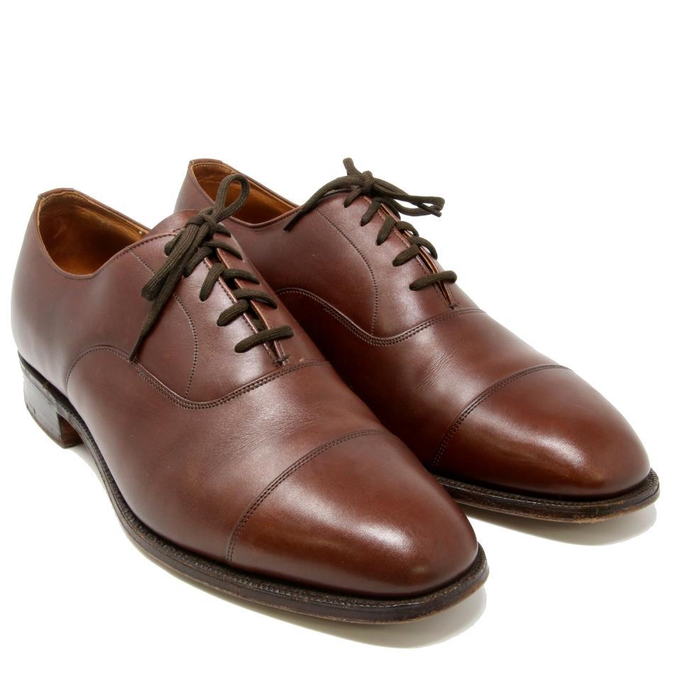 Zapatos de vestir de cordones de piel lisa con puntera de grado personalizado marrón

Zapato de vestir Church's Cap-toe Oxford talla 8 en piel lisa marrón. Los zapatos Church son un elemento básico en el armario de cualquier hombre por su estilo y