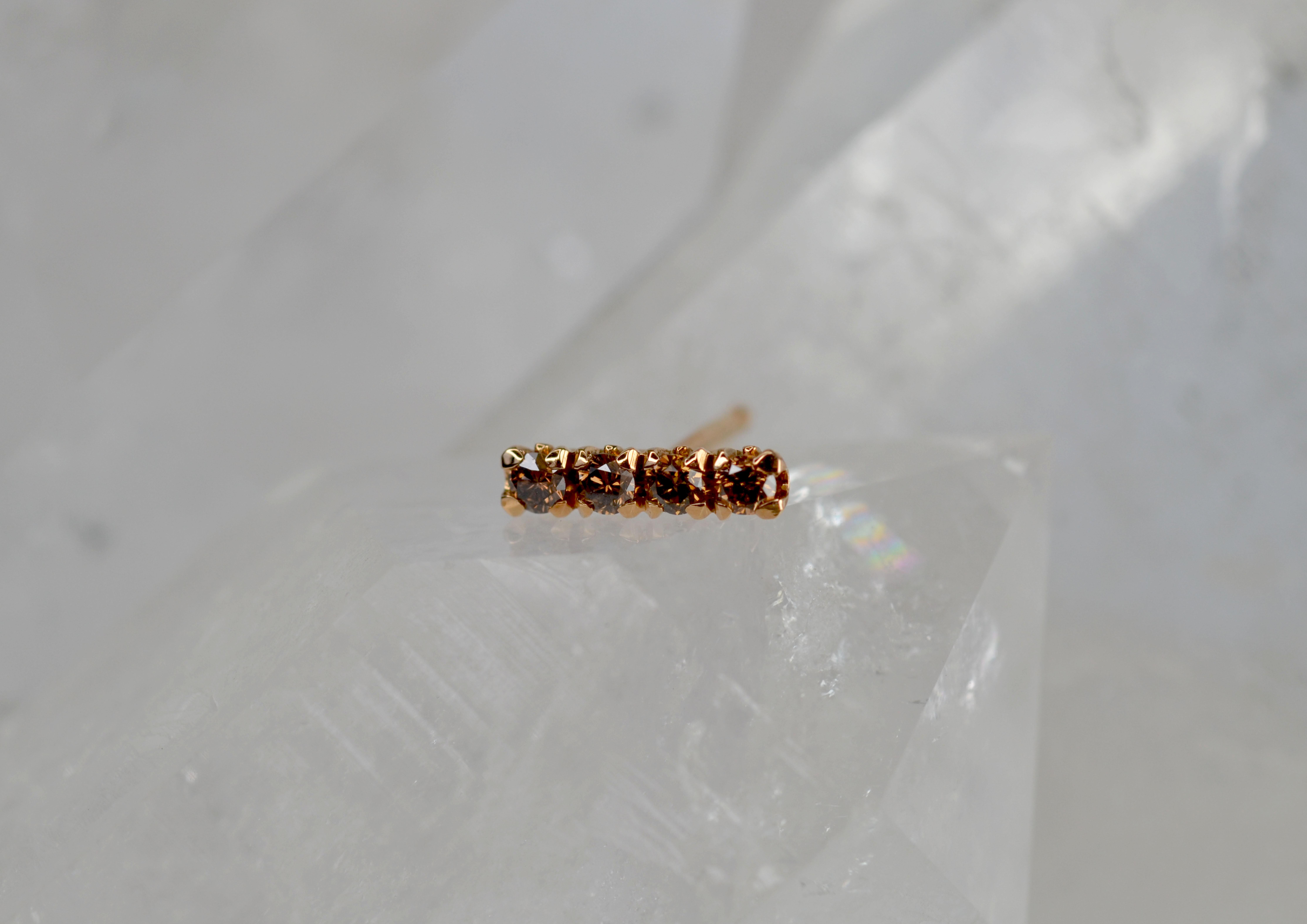 This single earring stud is part of our Blossom Collection of mix and match pieces. The glistening brown diamonds are set on an 18k gold blossom flower collet to be worn alongside your favourite pair of earrings, our blossom hoops, or combine with