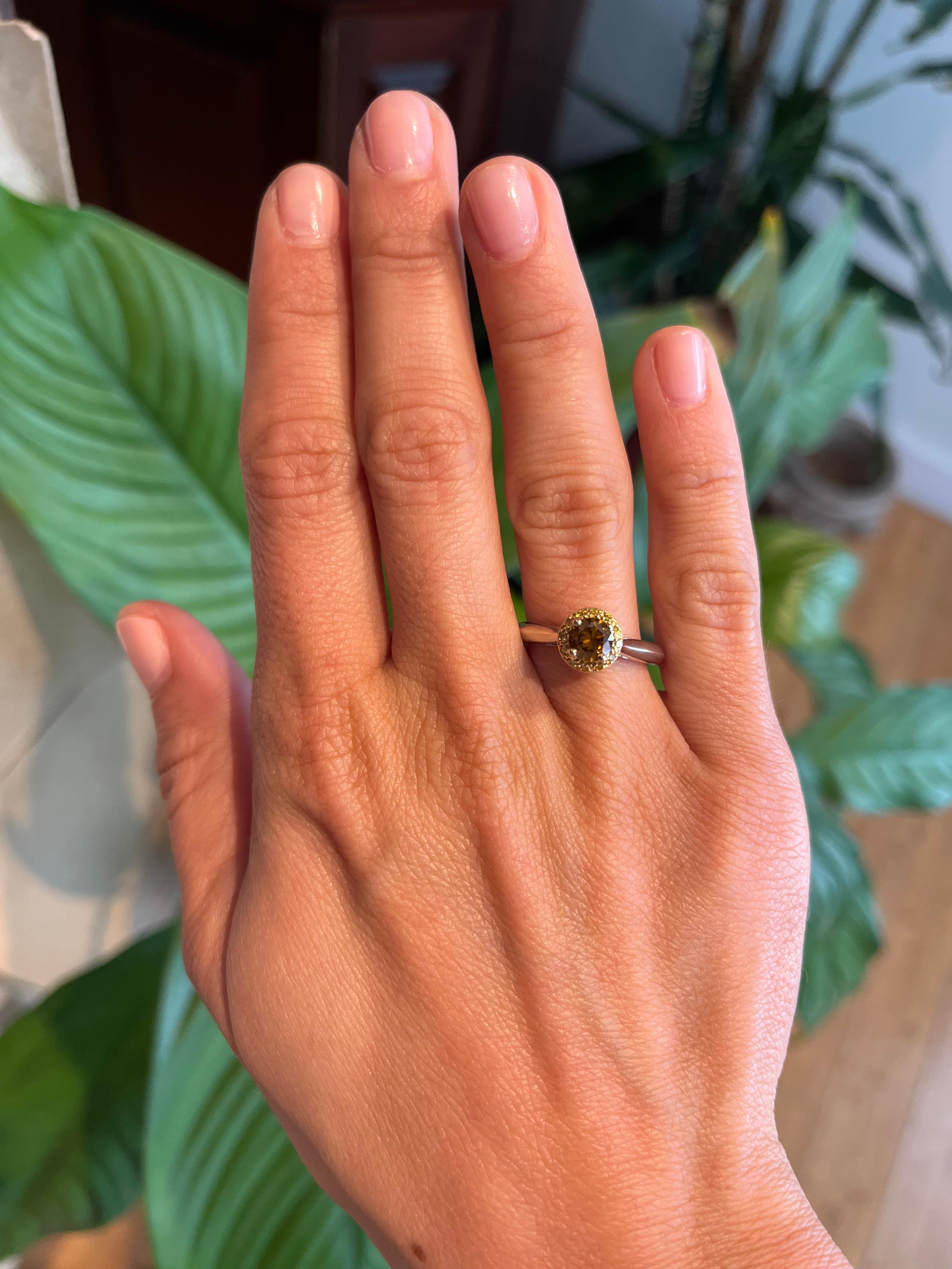 A unique engagement ring set with a colorful mix of natural diamonds: at center is a 0.61ct deep brownish orange round brilliant cut diamond (I1 clarity, GIA certification), surround by 12 canary yellow diamonds on top and 22 white diamonds in a
