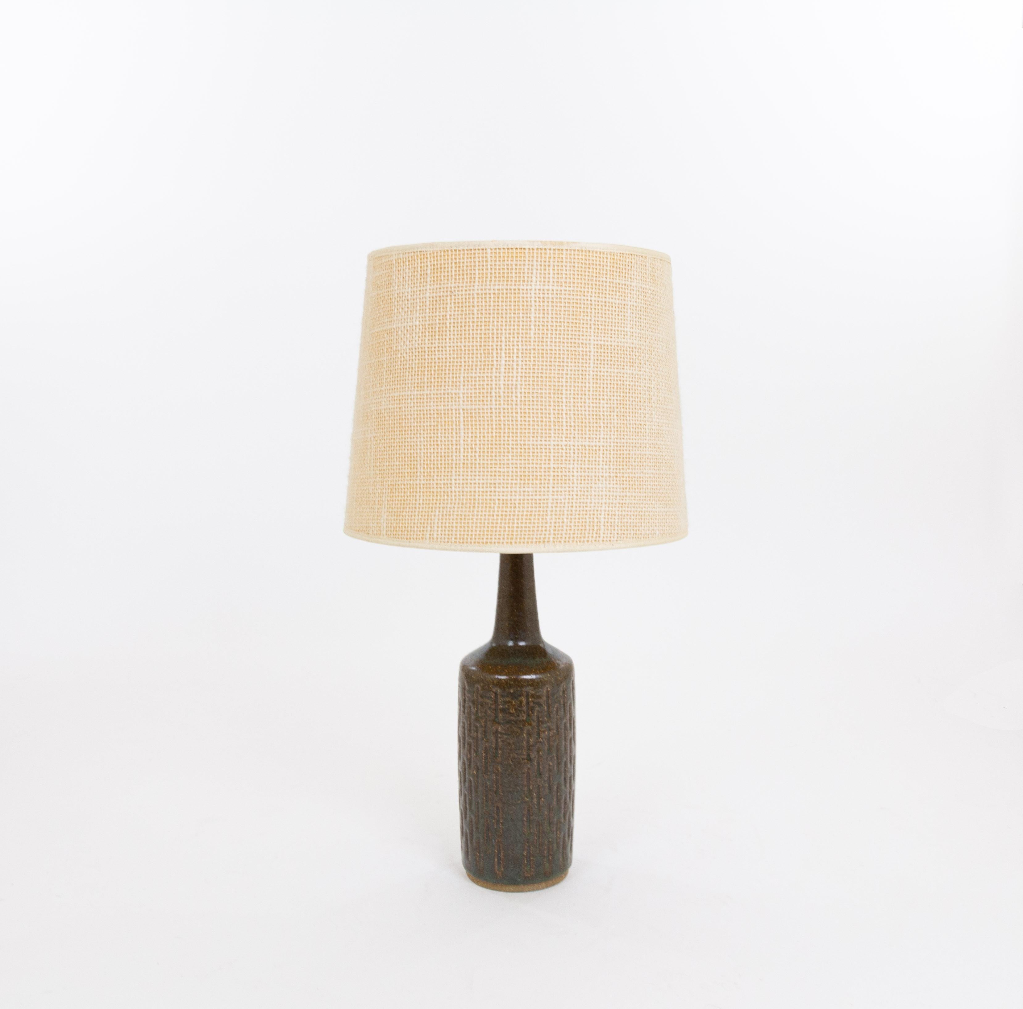Lampe de table modèle DL/30 réalisée par Annelise et Per Linnemann-Schmidt pour Palshus dans les années 1960. La couleur de la base décorée à la main est un mélange de brun et de vert. Il présente des motifs impressionnés.

La lampe est livrée avec