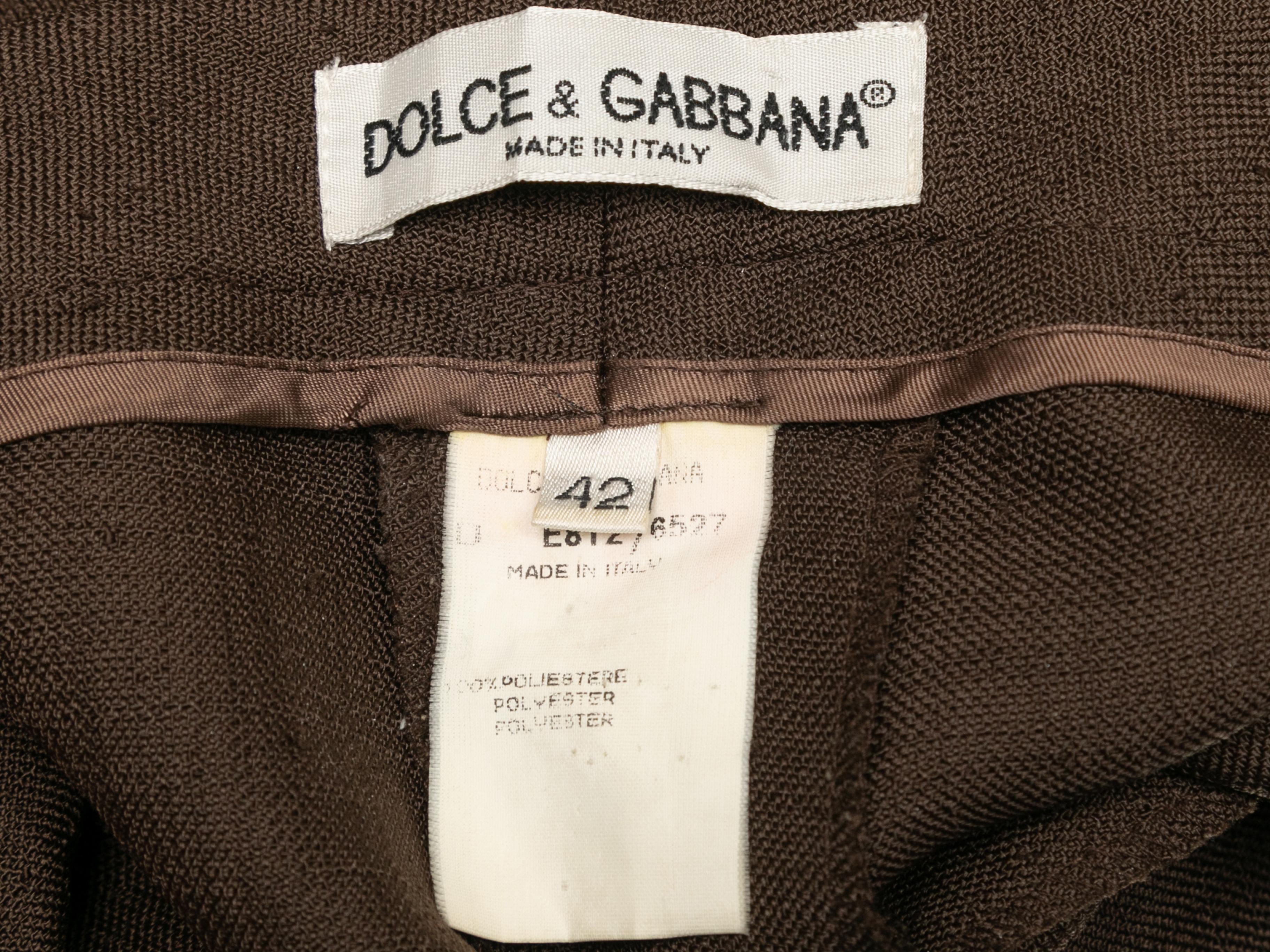 Pantalón marrón de Dolce & Gabbana. Blazer con solapa de muesca, mangas tres cuartos y cierres de botones delanteros. Los pantalones tienen dos bolsillos en la cadera y cierre frontal con cremallera. Blazer- 38
