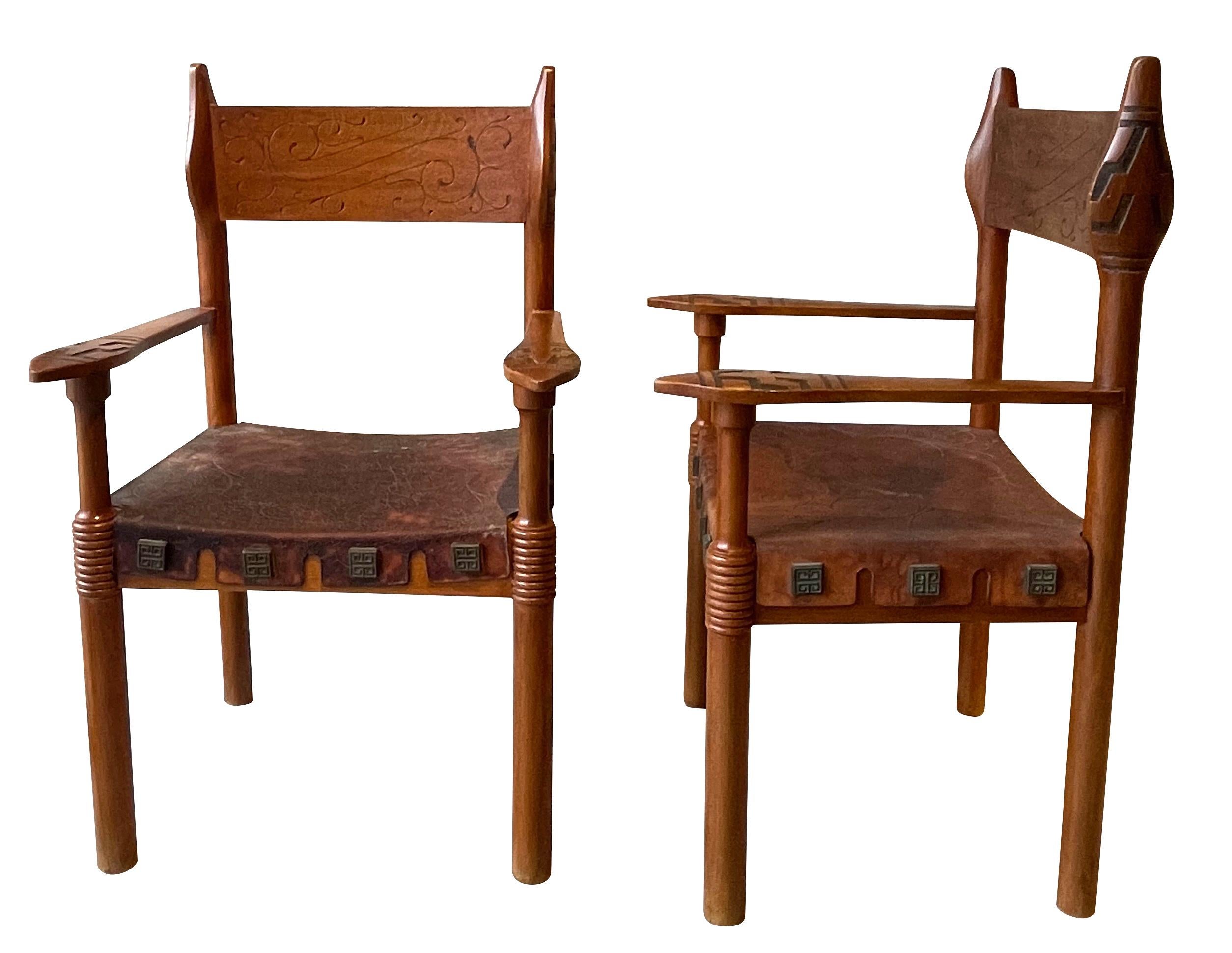 1970's Spanish pair wood frame, embossed leather seat chairs.
Unusual and very decorative carving on arms and sides of frame and back.
Embossed leather seats.
Engraved bronze rivets attaching leather to frame of chairs.
