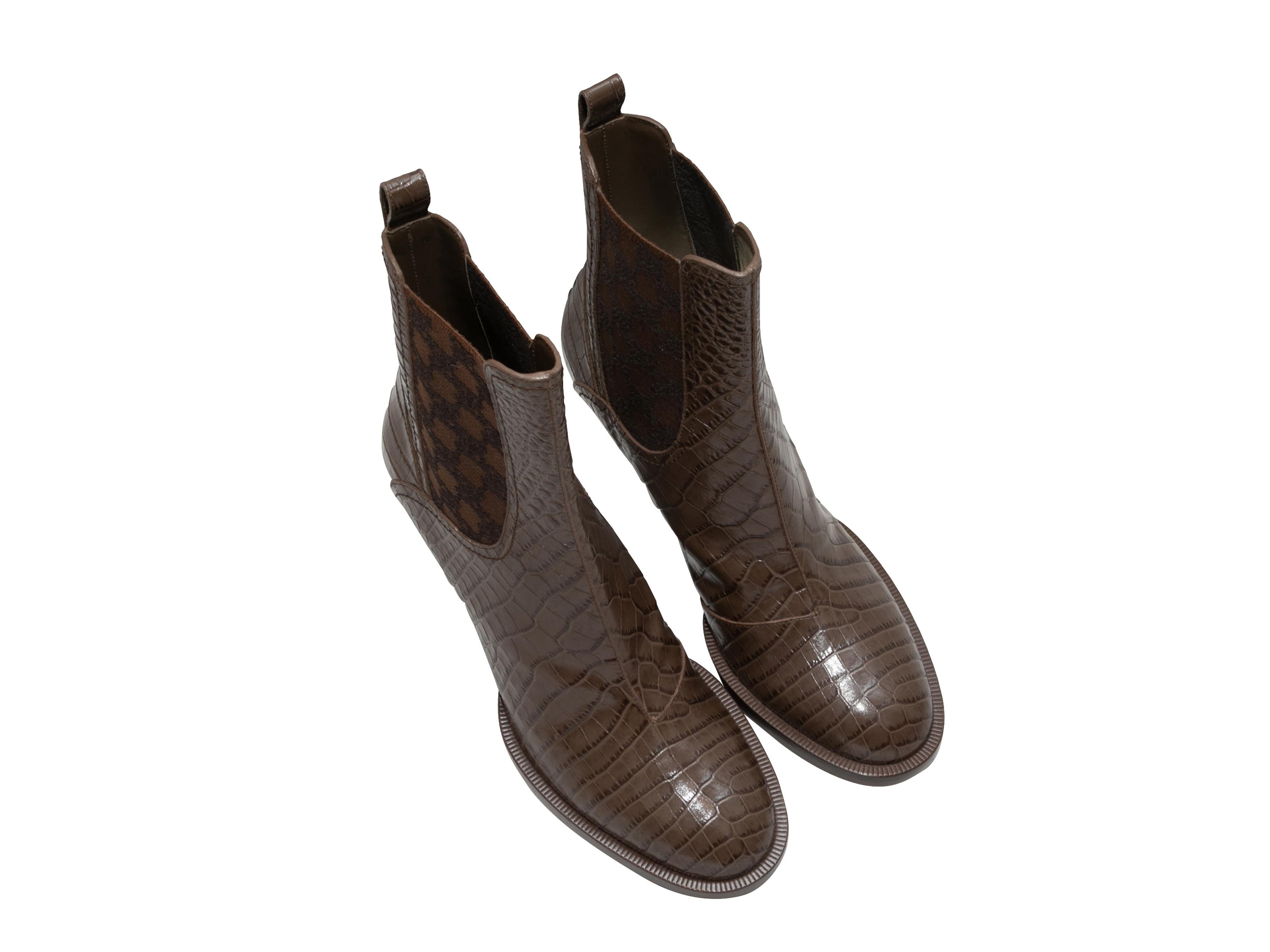 Detalles del producto: Botines con tacón de cocodrilo en relieve marrón de Fendi. Refuerzos elásticos estampados en los laterales. Tacones apilados. Altura de la caña 6