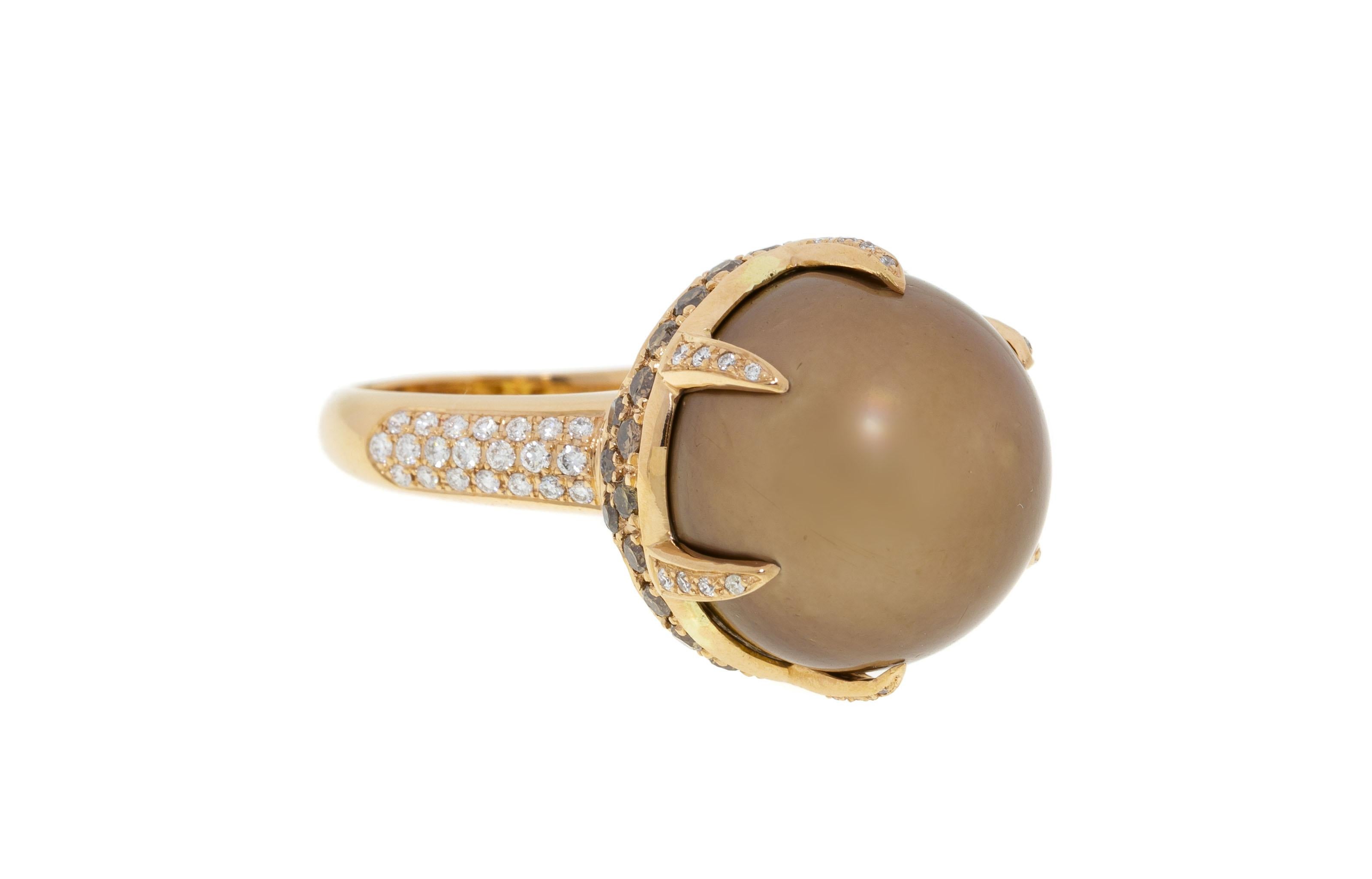 Gorgeous chocolate color pearl inlaid in a rose gold ring with white and black diamonds. The rare brown shade of the pearl is absolutely breathtaking. The warm color palette of the ring combines pink ocher chocolate and beige tones which always look