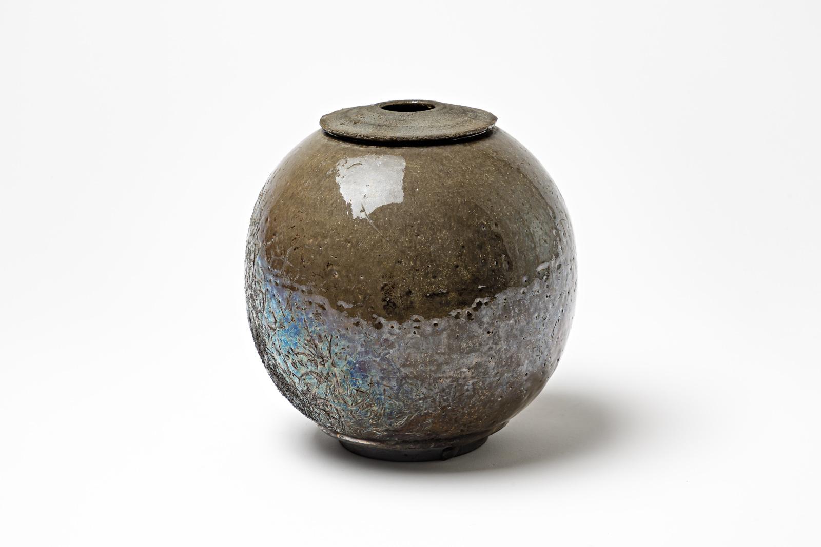 Brown glazed stoneware vase with metallic highlights by Gisèle Buthod Garçon. Raku fired. Artist monogram under the base. Circa 1980-1990.
H : 7.5’ x 6.7’ inches.