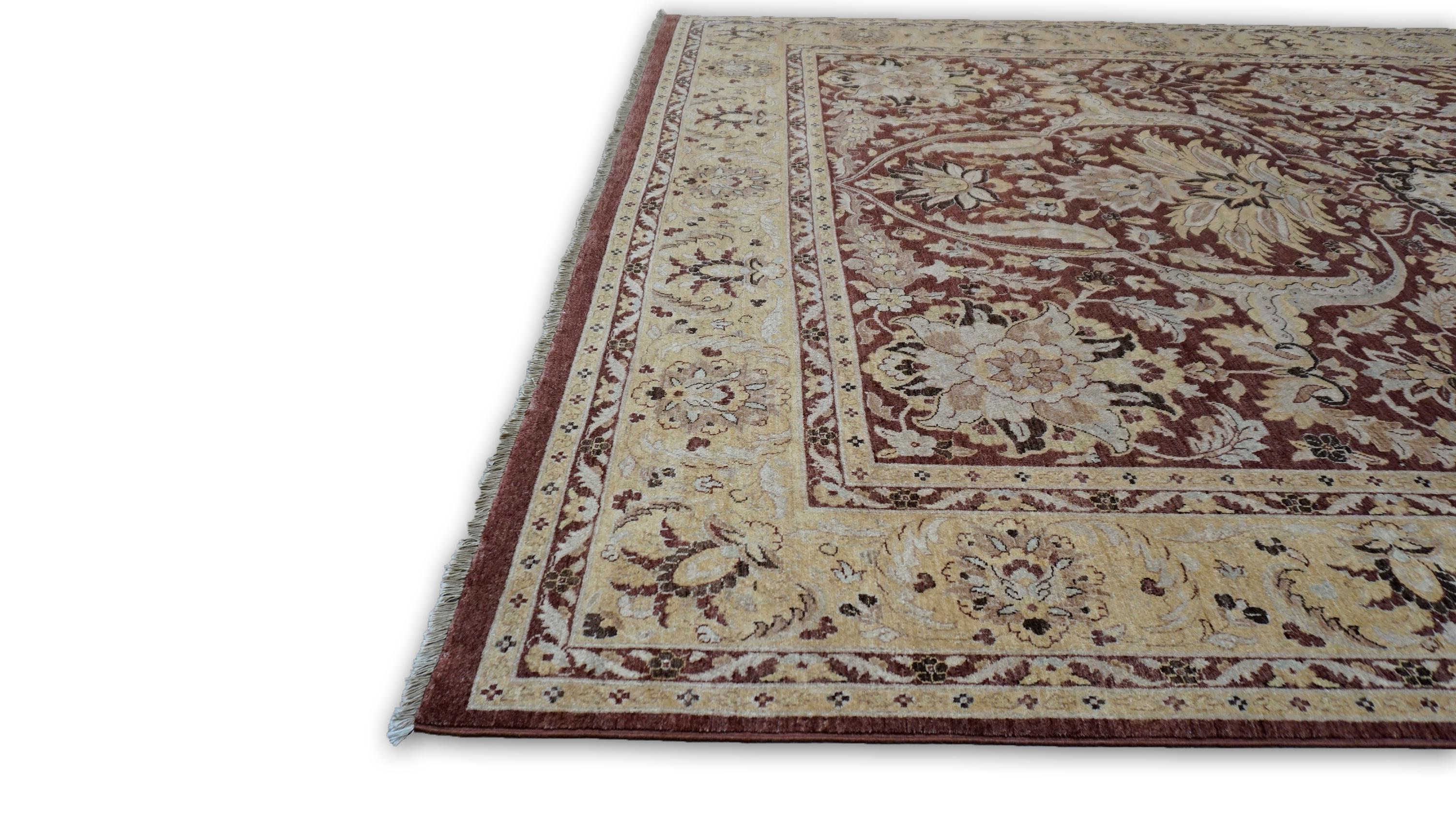 This exquisite hand-knotted wool rug is a testament to master craftsmanship, inspired by classic designs. The central medallion is framed by elaborate botanical motifs, with a rich brown field that contrasts beautifully against gold, tan and ivory