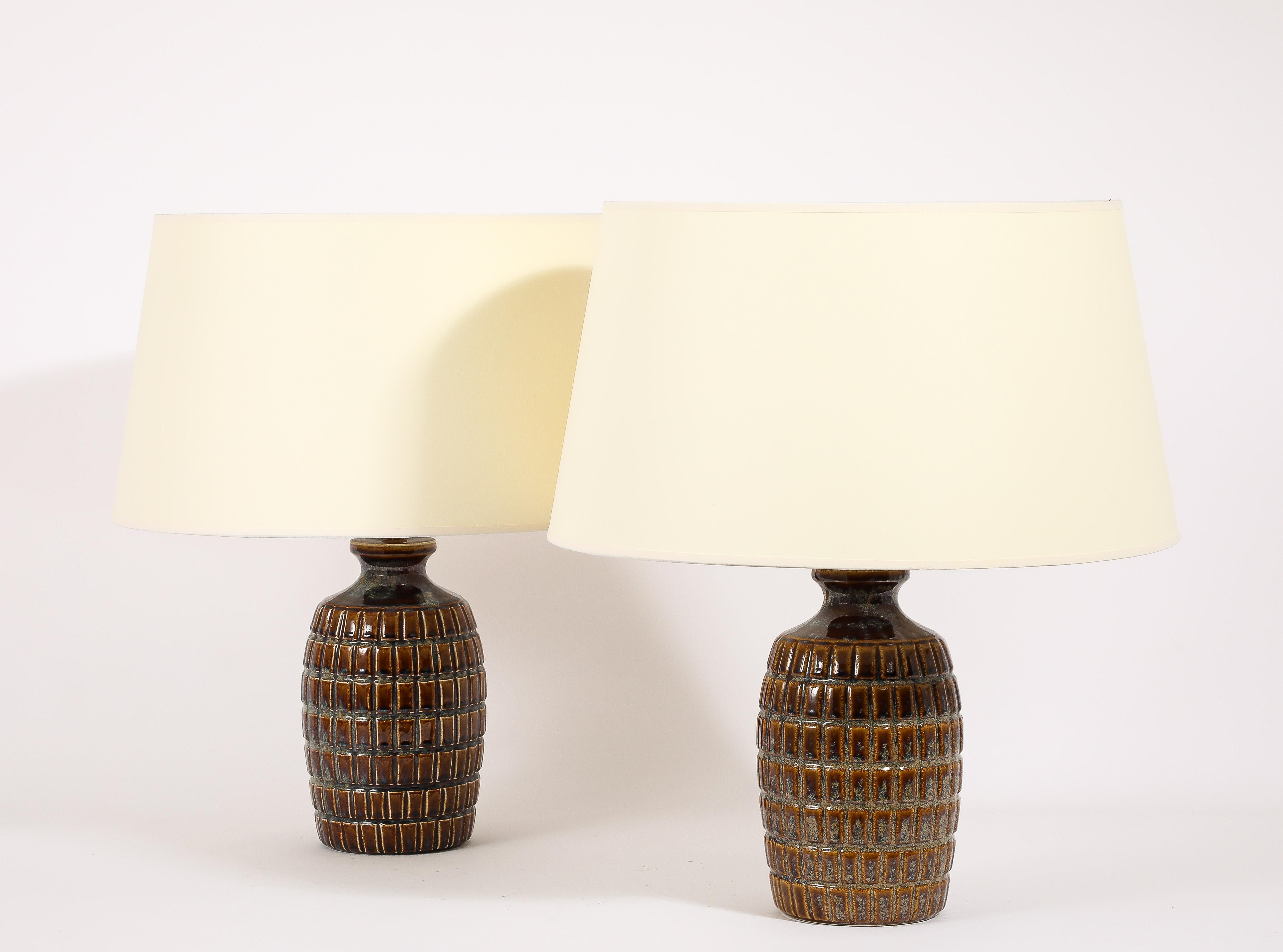 Pair of blue & brown glazed table lamps with a geometrical pattern reminiscent of a grenade.

Base size only 16x8.
