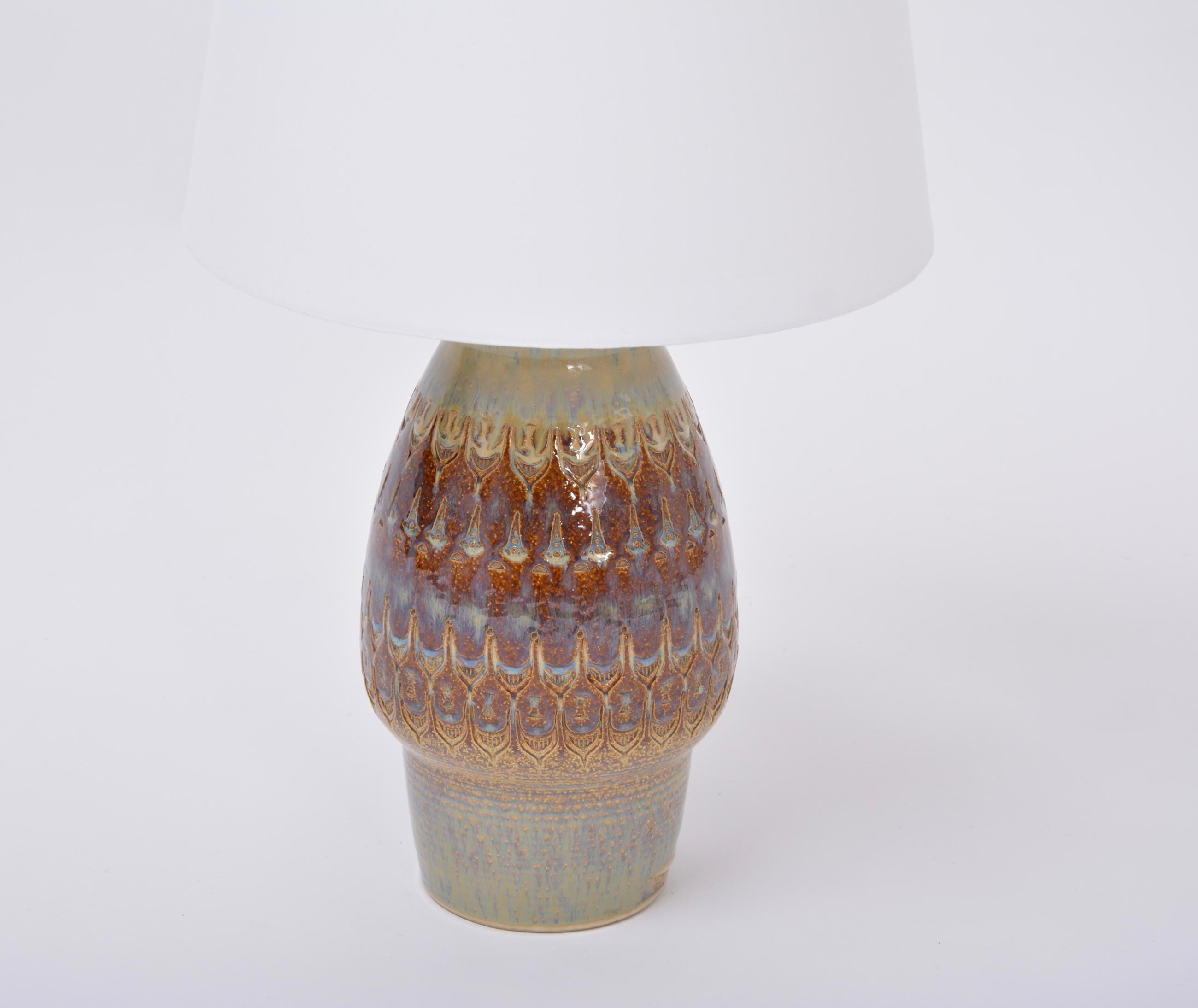 Brown handmade Mid-Century Modern Danish stoneware table lamp by Soholm Stentoj

Spectacular tall table lamp made of stoneware with ceramic glazing in various tones of brown. The base of the lamp features various graphic patterns. Handmade in