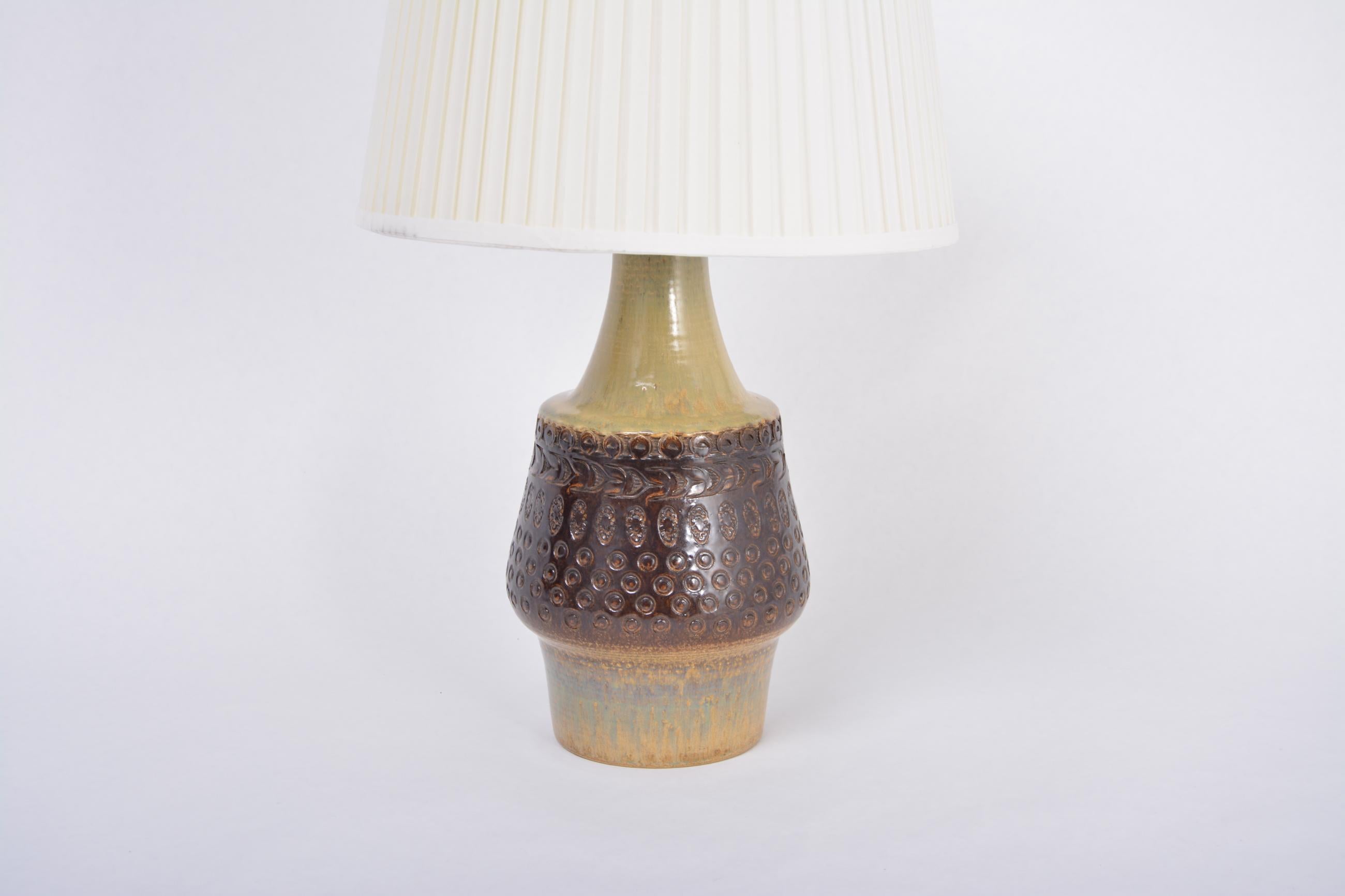 Brown handmade Mid-Century Modern Danish stoneware table lamp by Soholm Stentoj

Spectacular tall table lamp made of stoneware with ceramic glazing in various tones of brown and yellow. The base of the lamp features various graphic patterns.