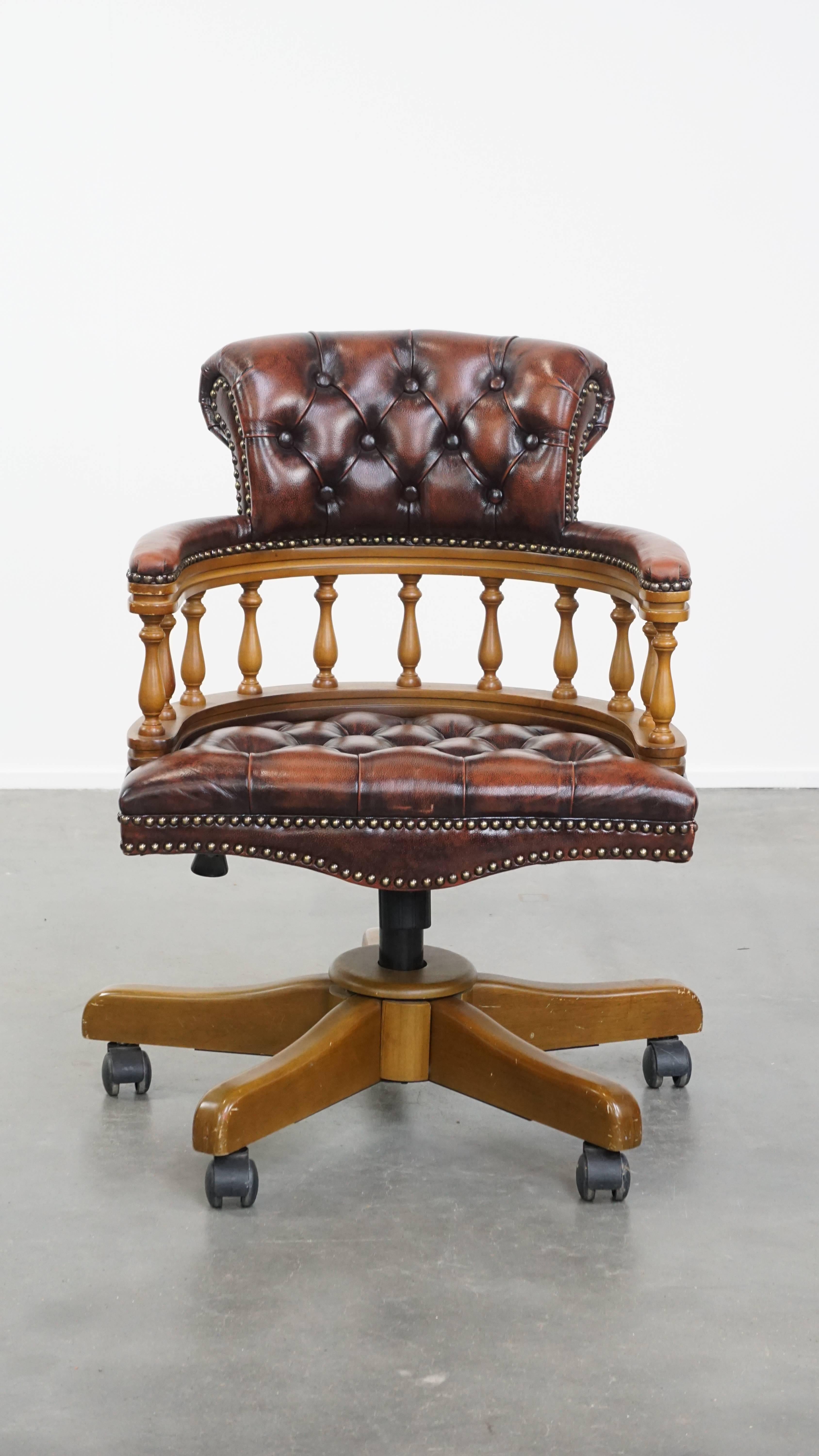 Angeboten wird dieser braune klassische höhenverstellbare Chesterfield Bürostuhl aus Rindsleder und Holz auf Rollen. Dieser elegante Bürostuhl aus Leder und Holz ist eine zeitlose Ergänzung für jeden Arbeitsplatz. Er ist schwenkbar, neigbar und