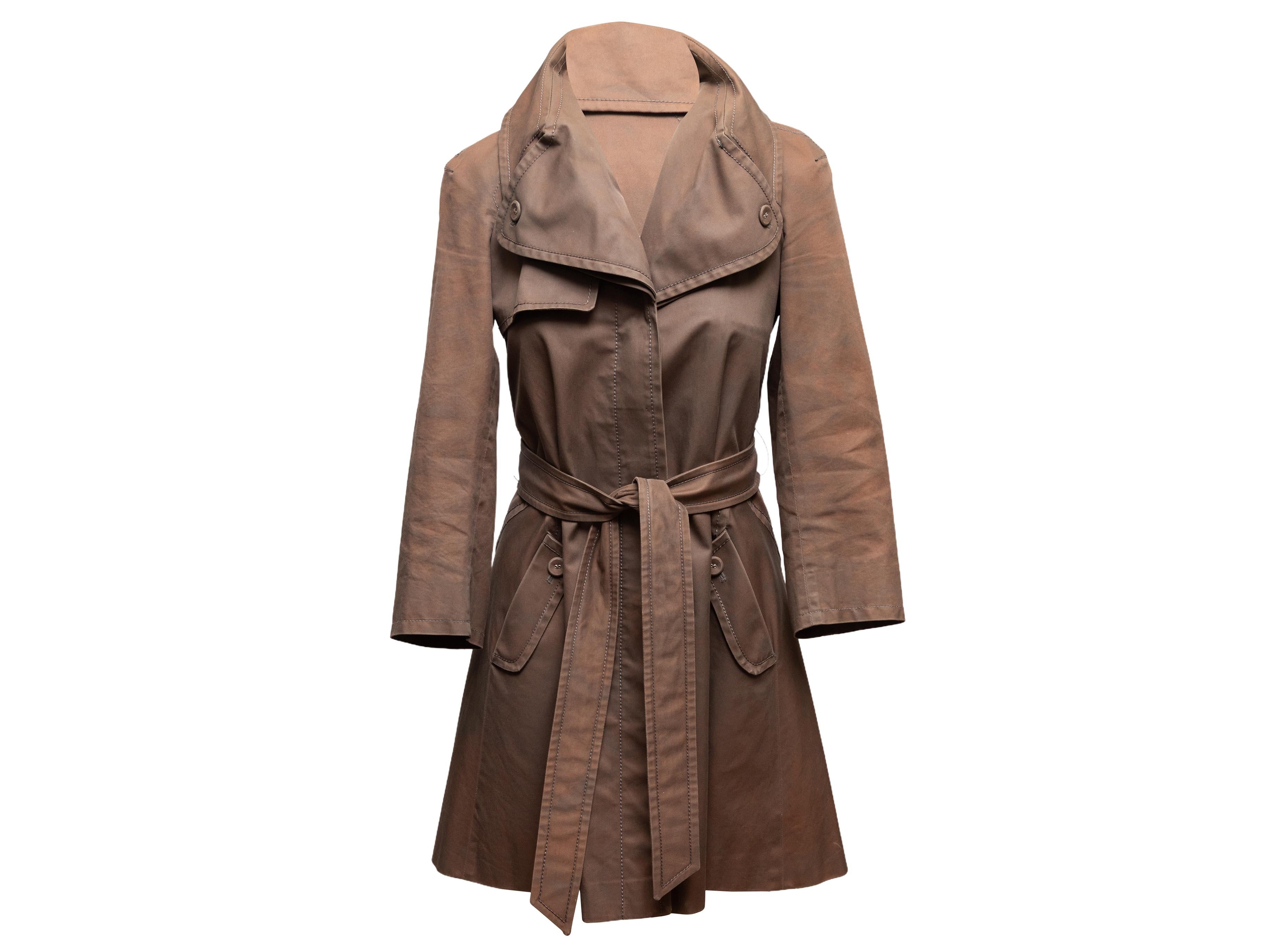 Trench-coat ceinturé en coton marron par Hussein Chalayan. Col surdimensionné. Deux poches sur les hanches. Fermeture cachée par bouton et ceinture. Buste de 32