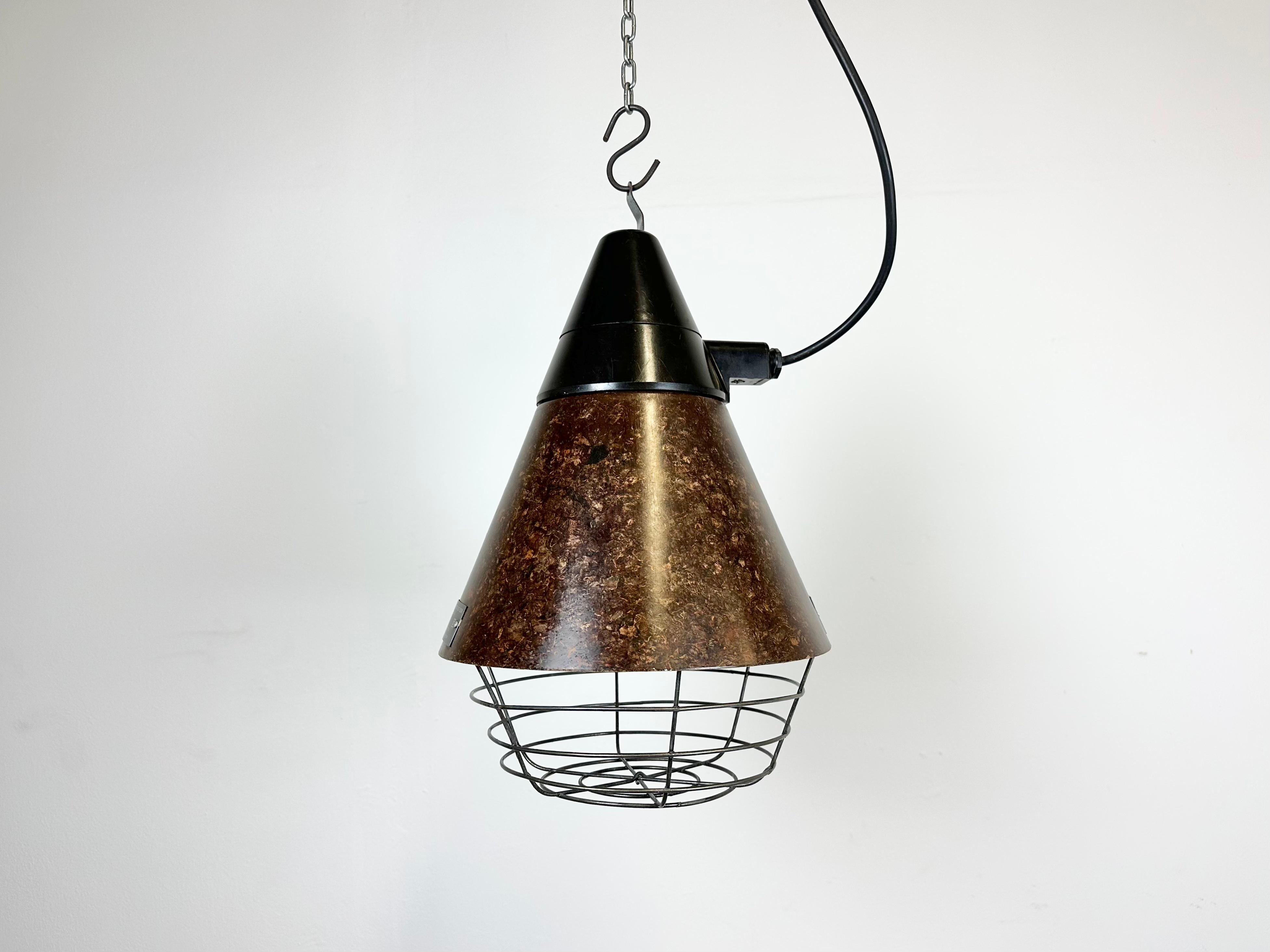 Former barn light was used as a infra-red light to keep the animals warm. Made by VEB NARVA ARTAS ARNSTADT DDR in East Germany during the 1960s. It features a brown bakelite conic lampshade and iron grid. The original socket requirers E 27/ E 26