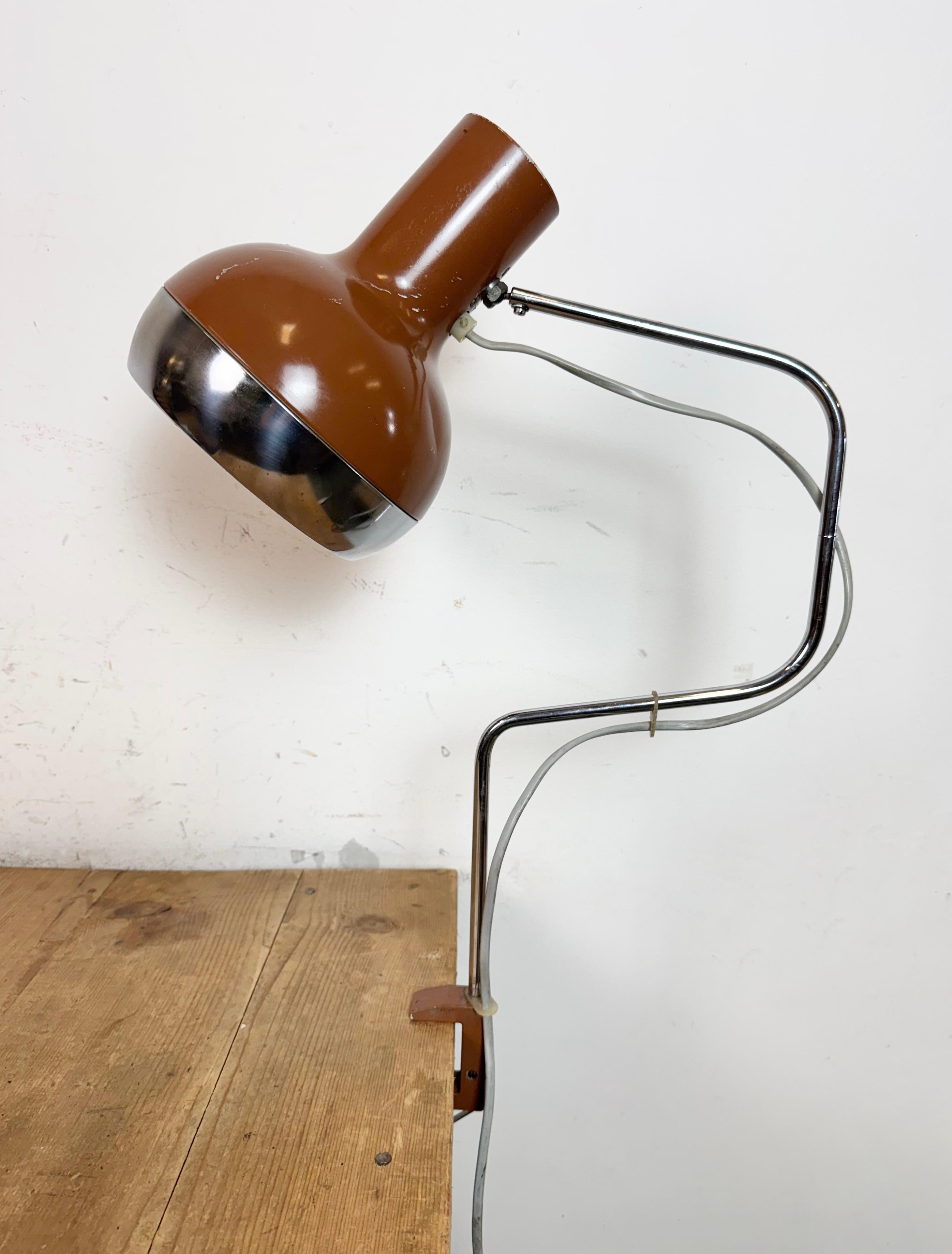Marrón vintage  Lámpara de mesa de oficina fabricada en la antigua Checoslovaquia durante la década de 1970. Presenta una pantalla de metal marrón,una base de pinza de hierro con  y un brazo cromado..El enchufe original requiere el estándar 