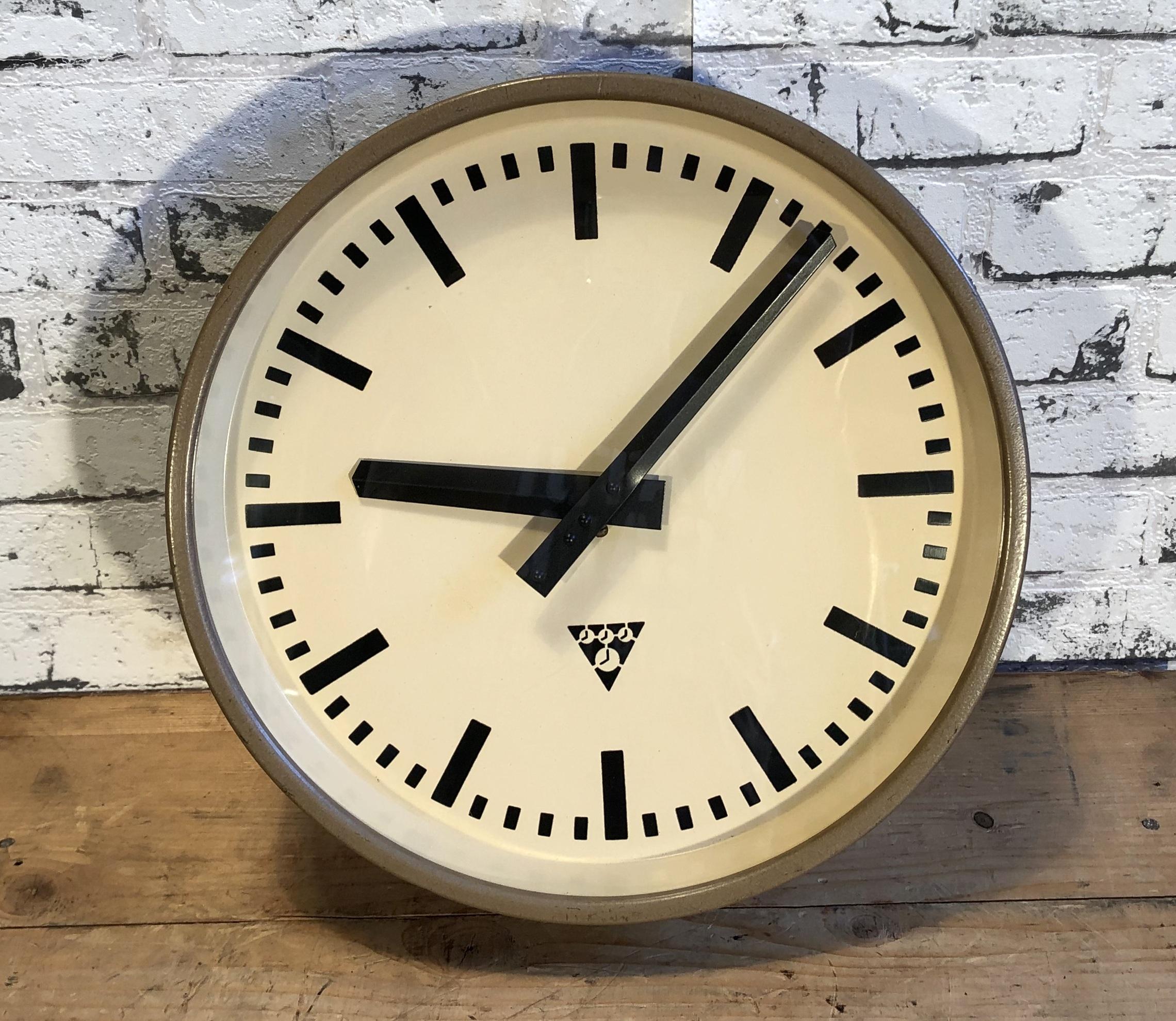 Pragotron wall clock made in former Czechoslovakia during the 1960s. It Features a brown hammer paint metal frame, iron dial and clear glass cover. The piece has been converted into a battery-powered clockwork and requires only one