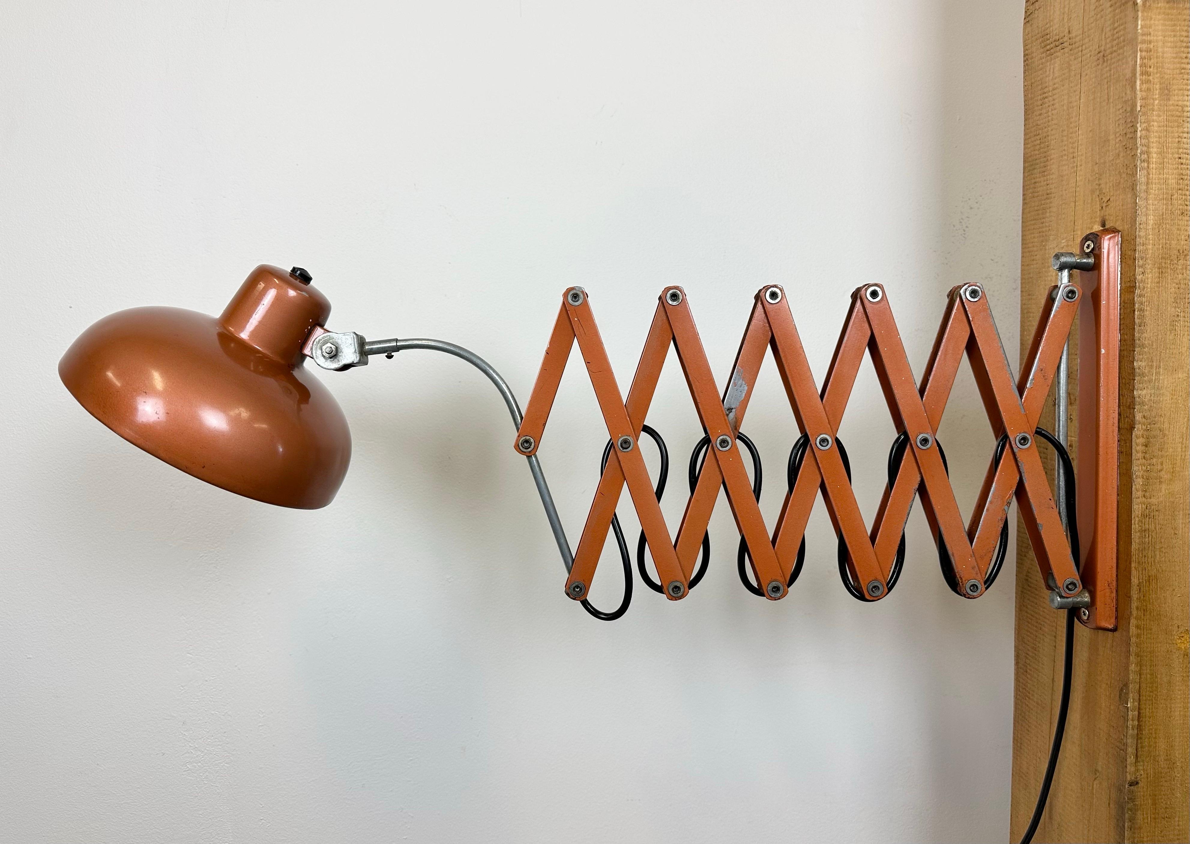 Industrial scissor wall lamp manufactured in Italy during the 1960s. The lamp has a metal shade. The iron scissor arm is extendable and can be turned sideways. Original swich is situated directly on the shade.The socket requires E27/ E26 light