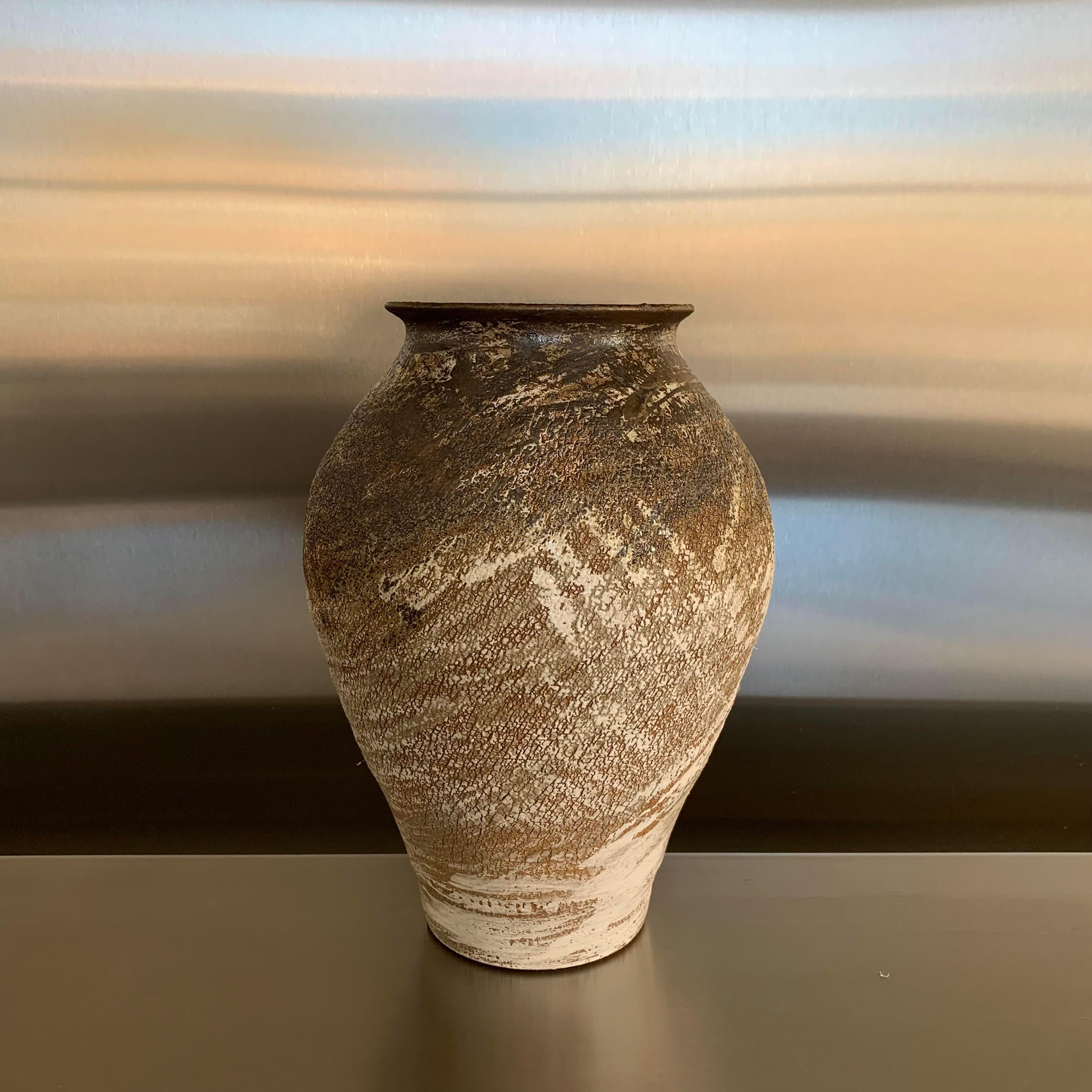 Contemporary American Ceramist Peter Speliopoulos stoneware vase.
The brown stoneware vessels are slipped in black and white, and then glazed with sweeping brushstrokes in various black, ivory and bronze glazes, to create an effect of erosion, as