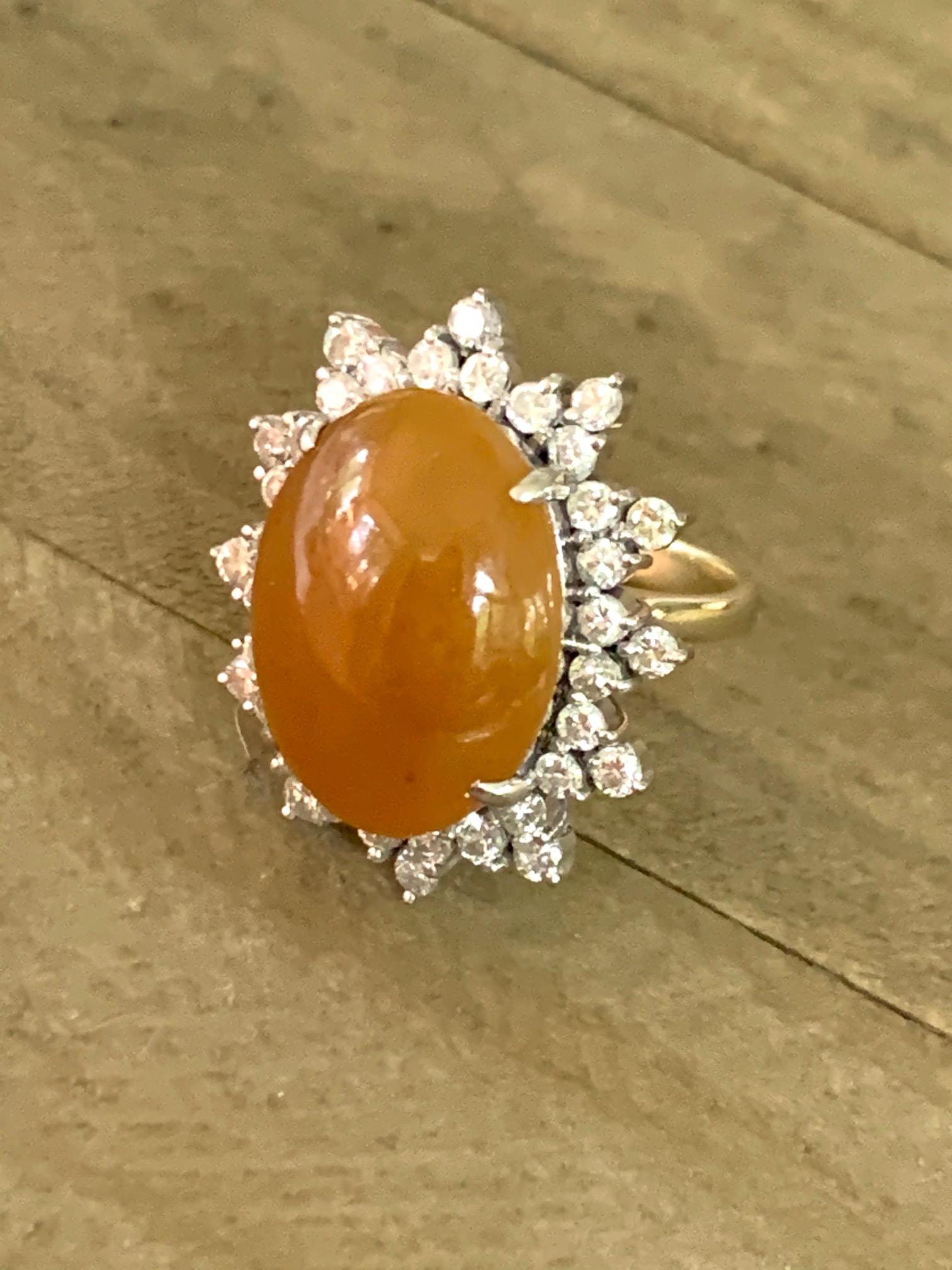 Dieser einzigartige Ring aus brauner Jade mit ovalem Cabochon ist ein echter Fund!  Er ist von einem Heiligenschein aus (36) 2::2 mm großen Diamanten im Brillantschliff umgeben.  Die Diamanten haben ein geschätztes Gesamtgewicht von 1::70cts mit