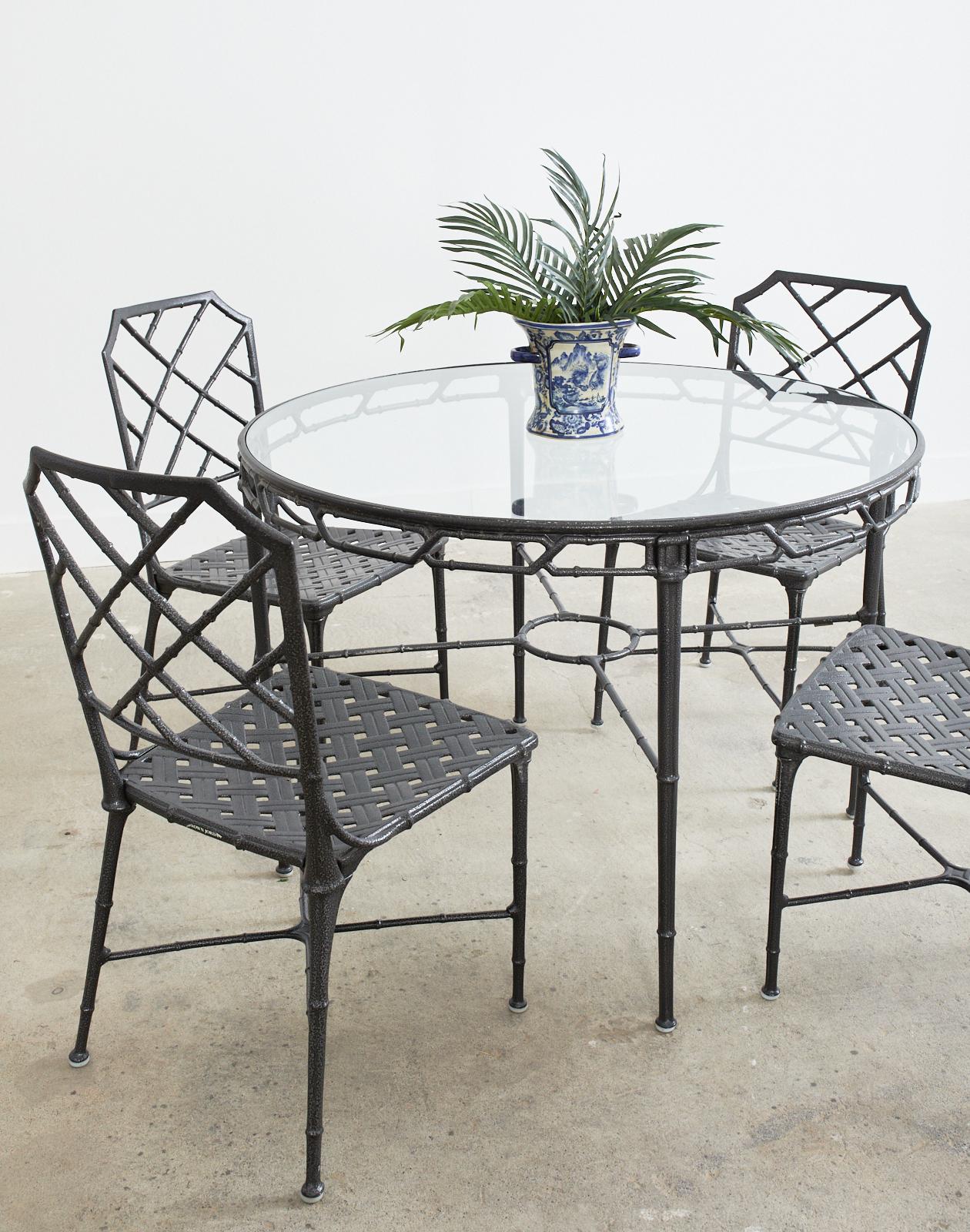 Iconic set of Calcutta patio and garden dining chairs and round 42 inch table designed by John Caldwell for Brown Jordan. Constructed from cast aluminum with a textured charcoal powder coated finish. The frames have a faux bamboo motif designed in