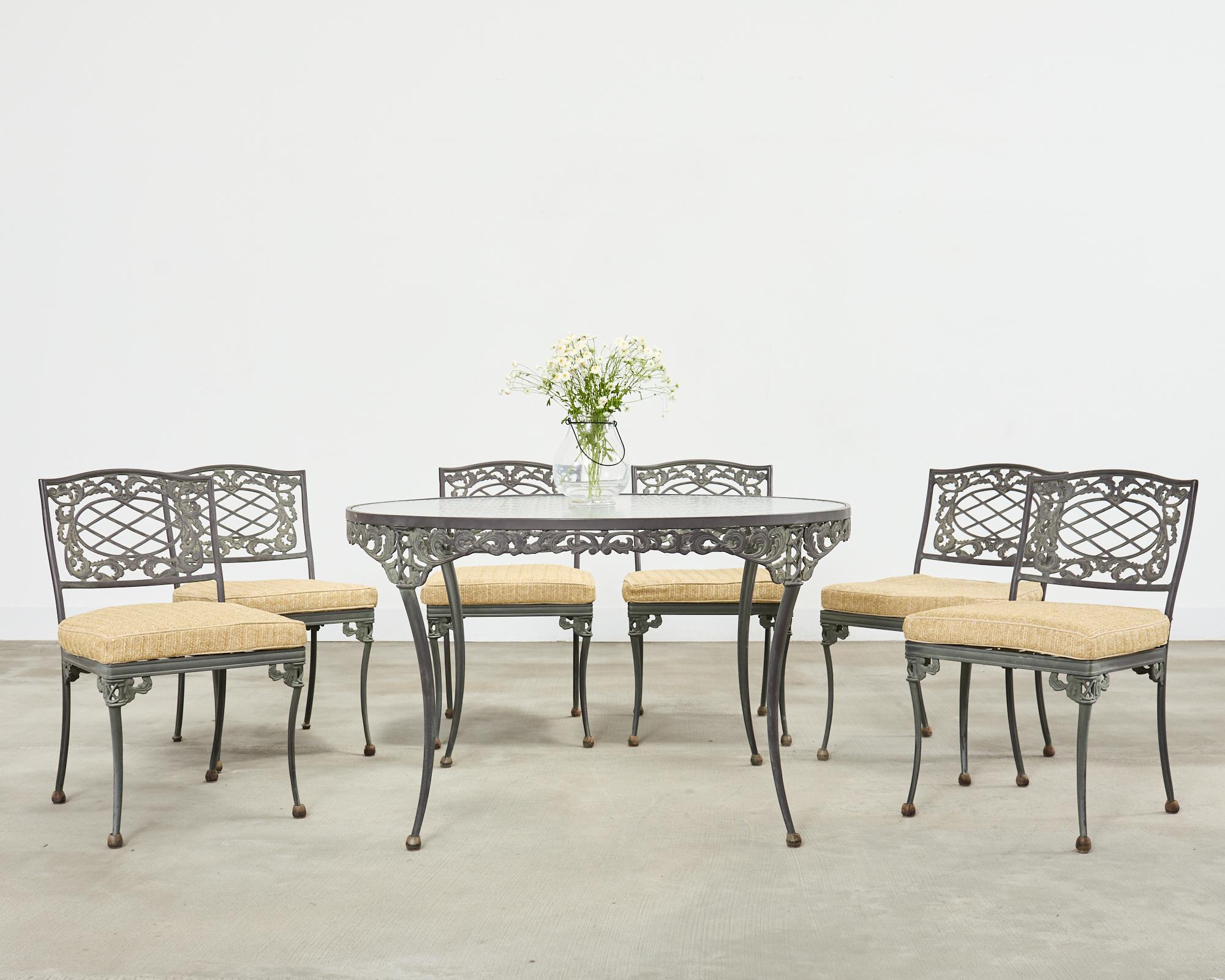 Genuine labeled Brown Jordan patio and garden dining suite consisting of six dining chairs (model #1210-1000), and a 48 inch round dining table (model #1211-4800). The Elegance collection is constructed from cast aluminum with an intentionally aged