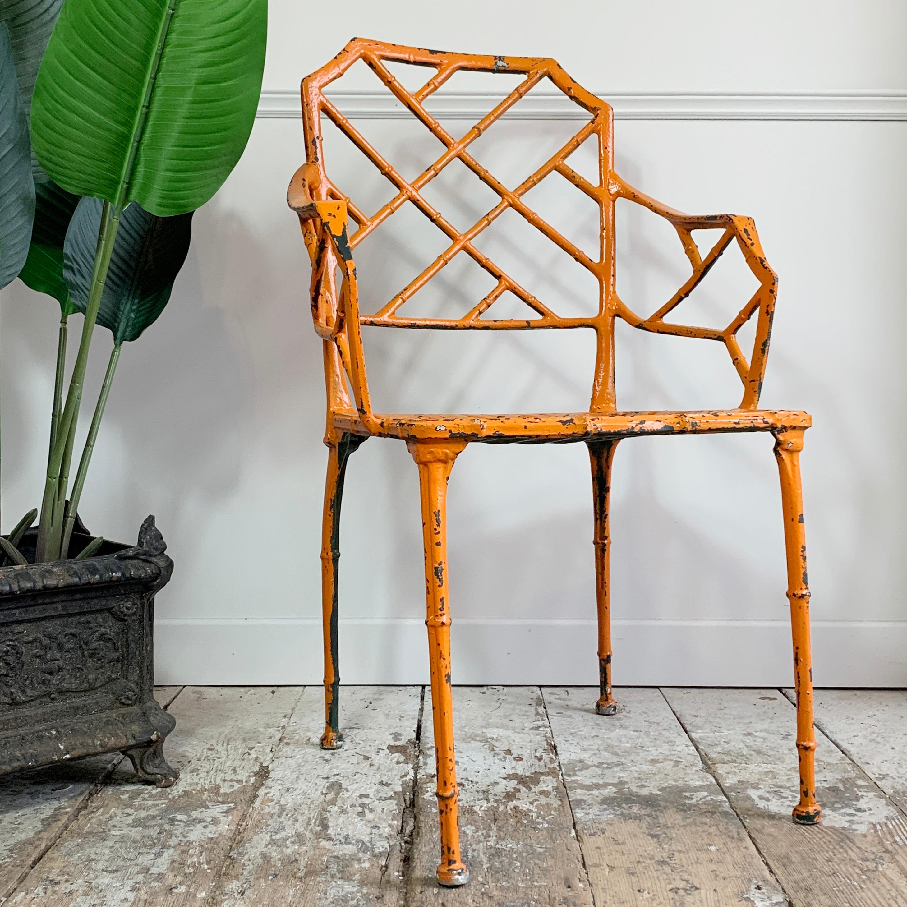Superbe chaise en faux bambou Brown Jordan Calcutta, inspirée par Chippendale. Cette chaise date des années 1960, elle a été repeinte au cours de sa vie et la couleur supérieure est maintenant un orange vibrant et frappant, ce qui, à notre avis, est