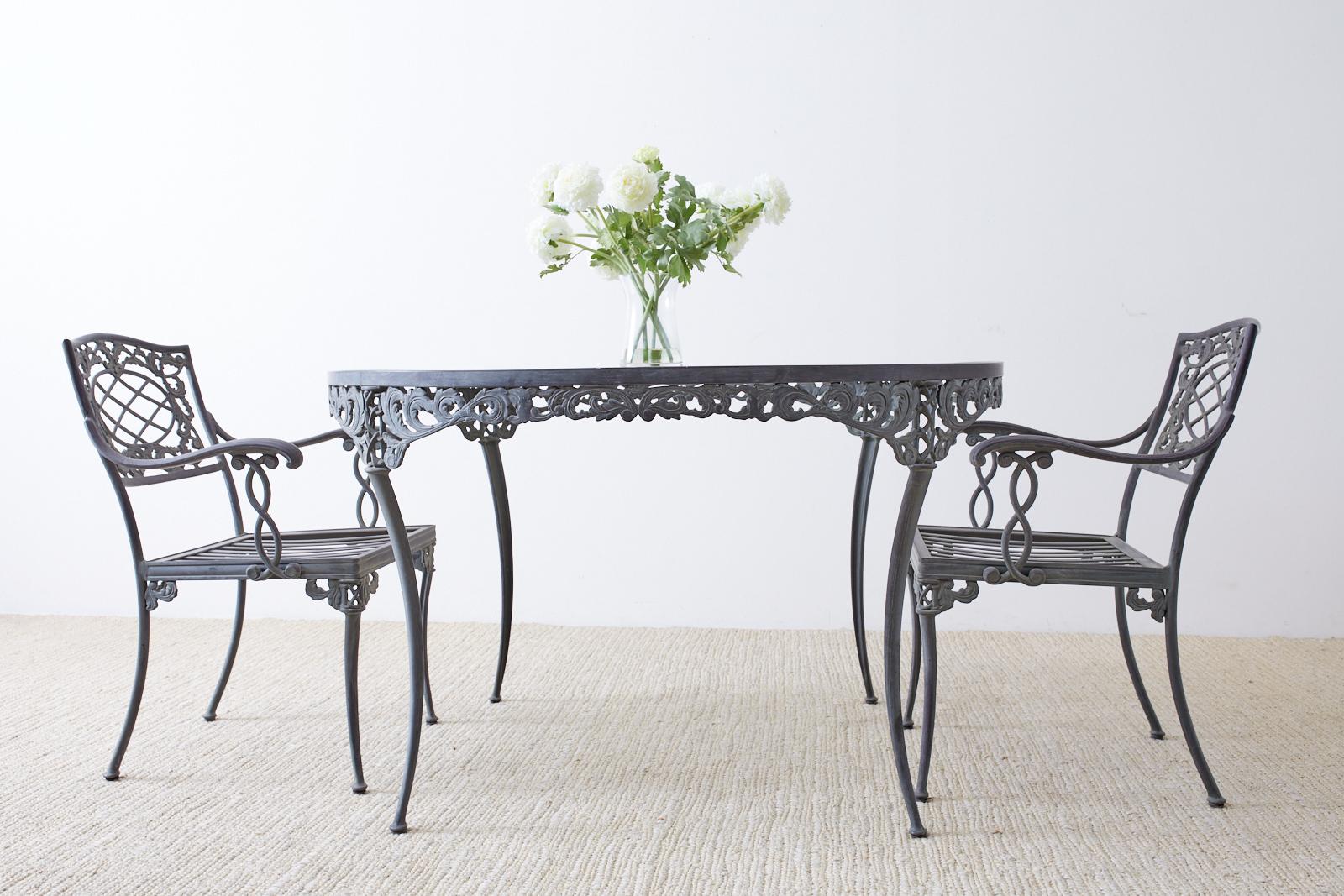 Gorgeous neoclassical style aluminum garden table or dining table made by Brown Jordan. This table features acanthus decorated aprons and is supported by graceful klismos style legs. The aluminum has a beautiful verdigris patina on the metal finish.
