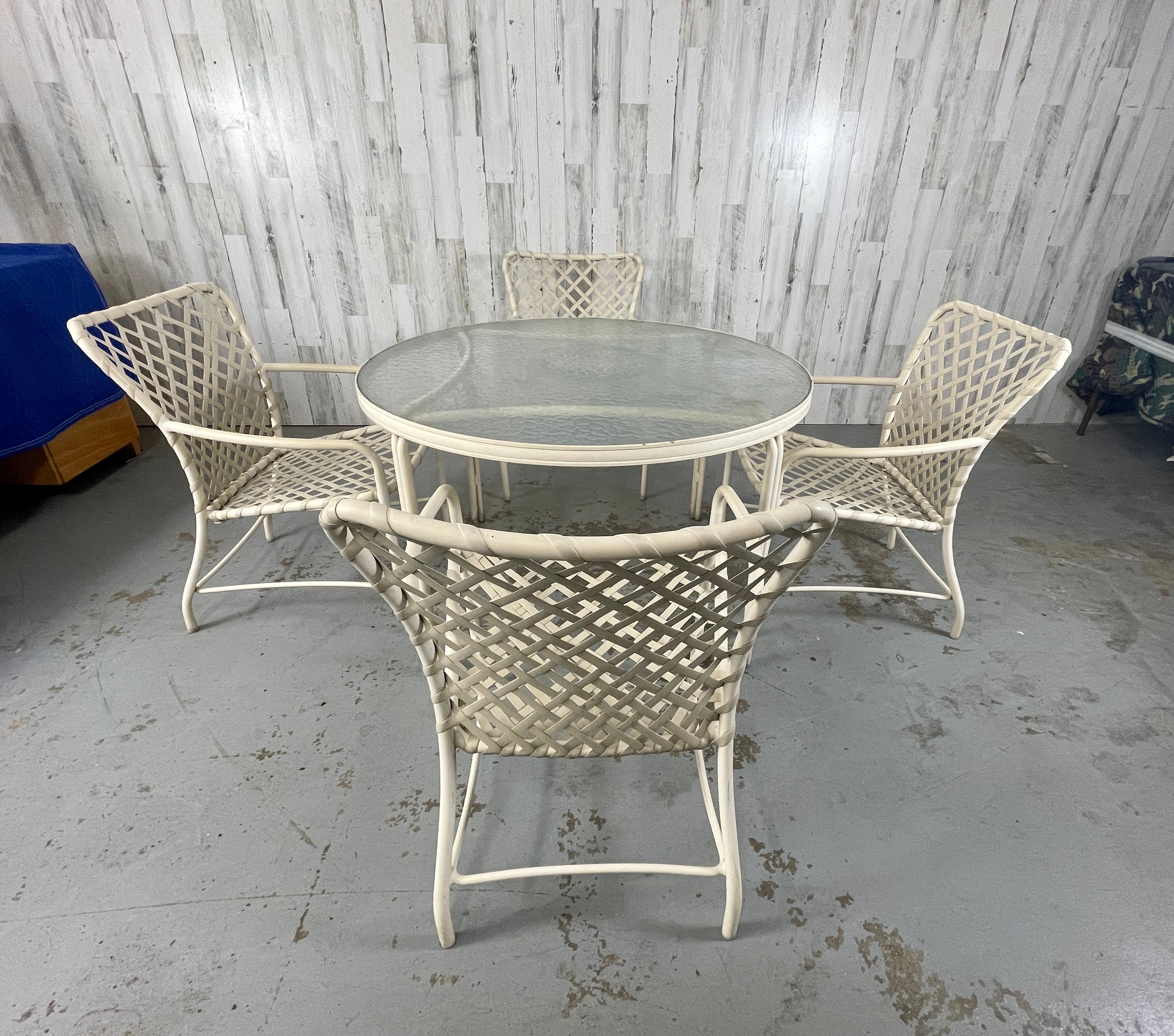 Brown Jordan Tamiami 5 Piece Patio Set. 1 round table and 4 armchairs designed and manufactured by Brown Jordan from the Tamiami Collection. Original Tan colored aluminum and strapping. The straps are sturdy and ready for use.

Table Measurements: