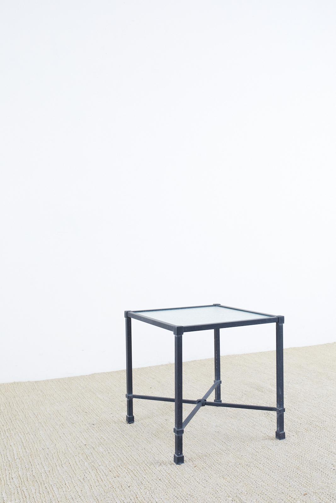 Neoclassical style cube shaped drink tables made by Brown Jordan constructed from powder-coated aluminum with a frosted glass inset top. The square legs are conjoined by an X-form stretcher with a decorative knot in the middle. From the Venetian