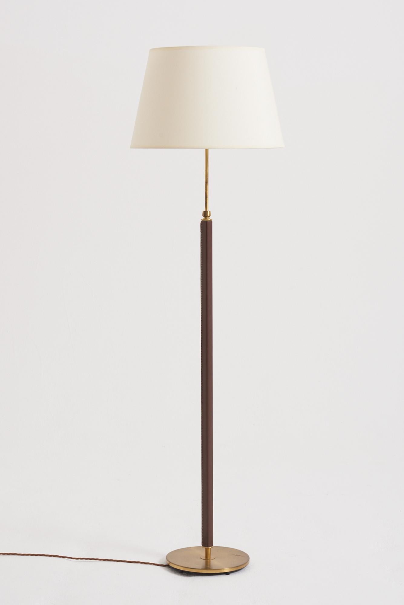 A brass and faux brown leather floor lamp by Falkenbergs Belysning. Sweden, third quarter of the 20th Century
With the shade: 142 cm high by 41 cm diameter
Lamp base only: 123 cm high by 23 cm diameter