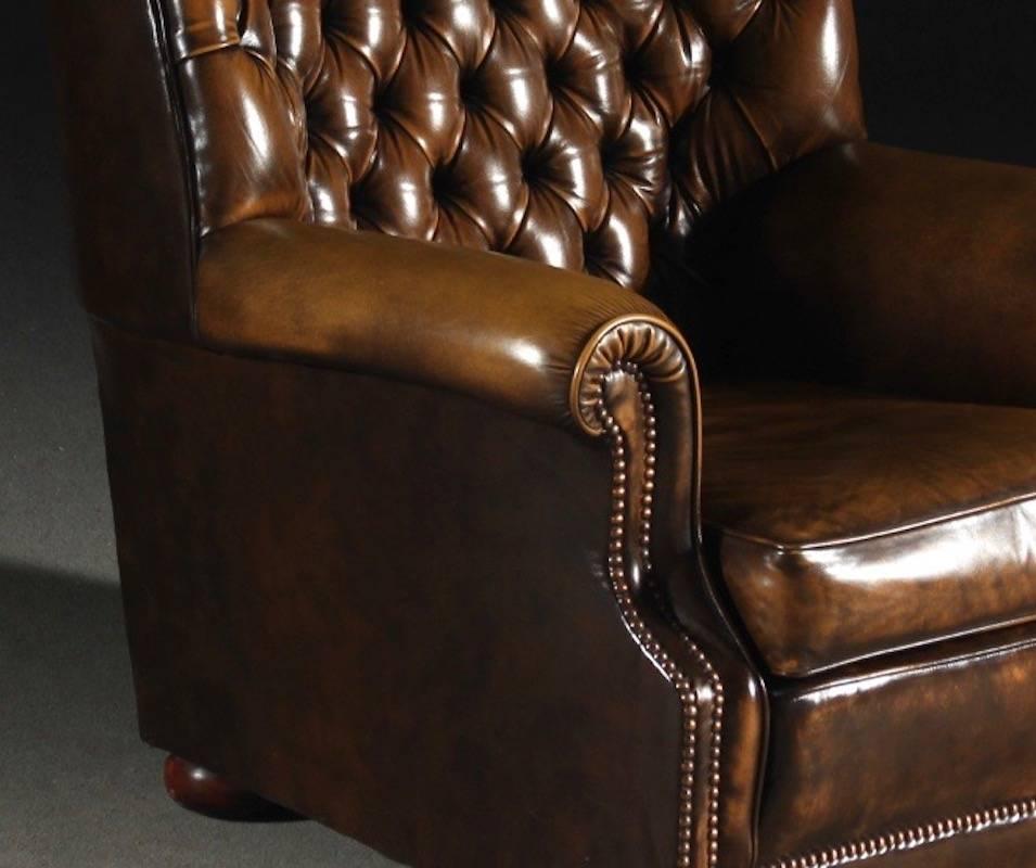 Chesterfield type armchair manufactured in England. Labelled Pegasus, Art Forma Upholstery Ltd. Brown leather button tufted upholstery, loose seat cushion, round wooden feet. Very comfortable.
   