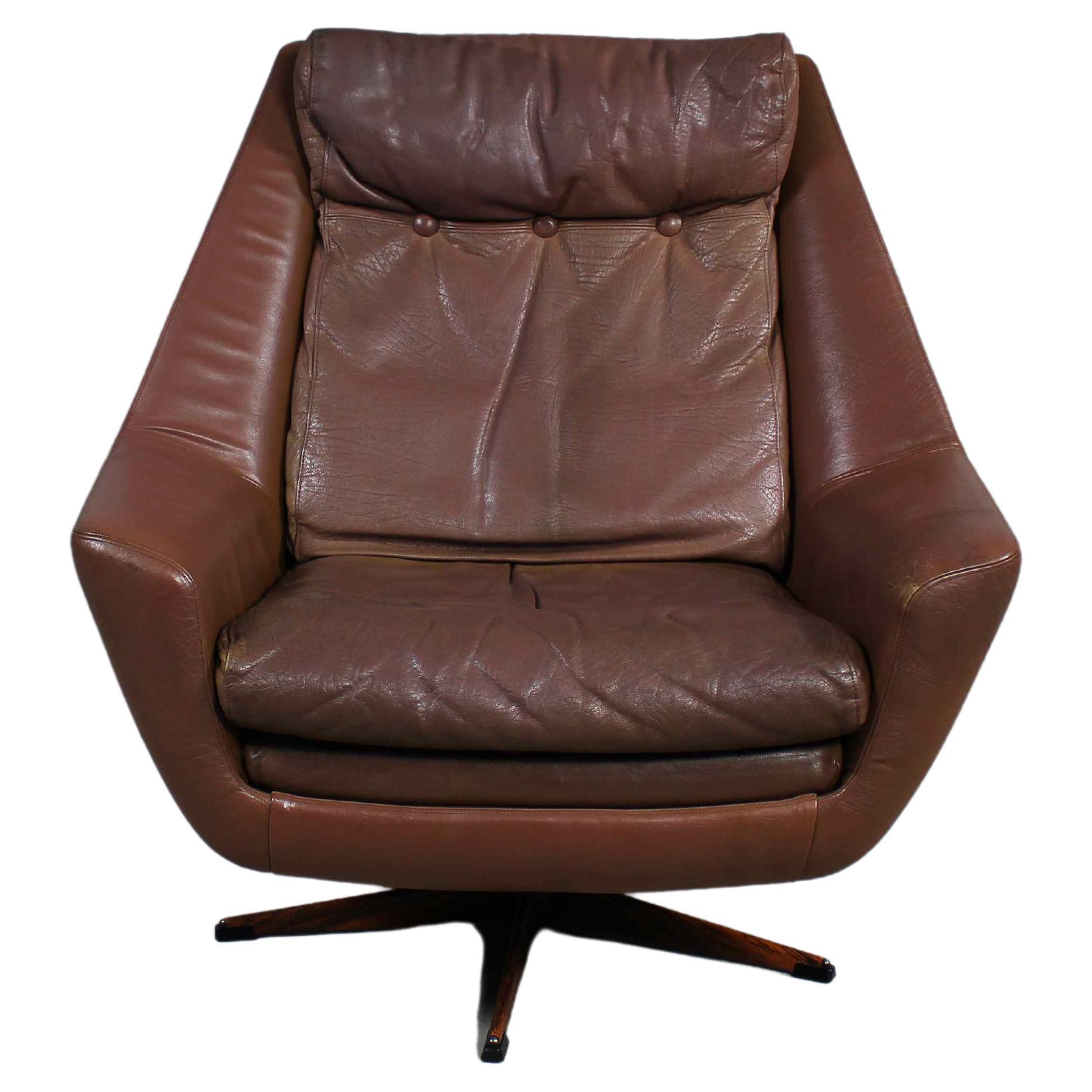 Fabriqué au Danemark dans les années 1960 par Erhardsen & Andersen,
Chaise de salon Retro Mid-Century Modern,
rembourré en cuir brun souple,
avec des coussins non fixés sur l'assise et le dossier,
sur une base pivotante à cinq étoiles.
 