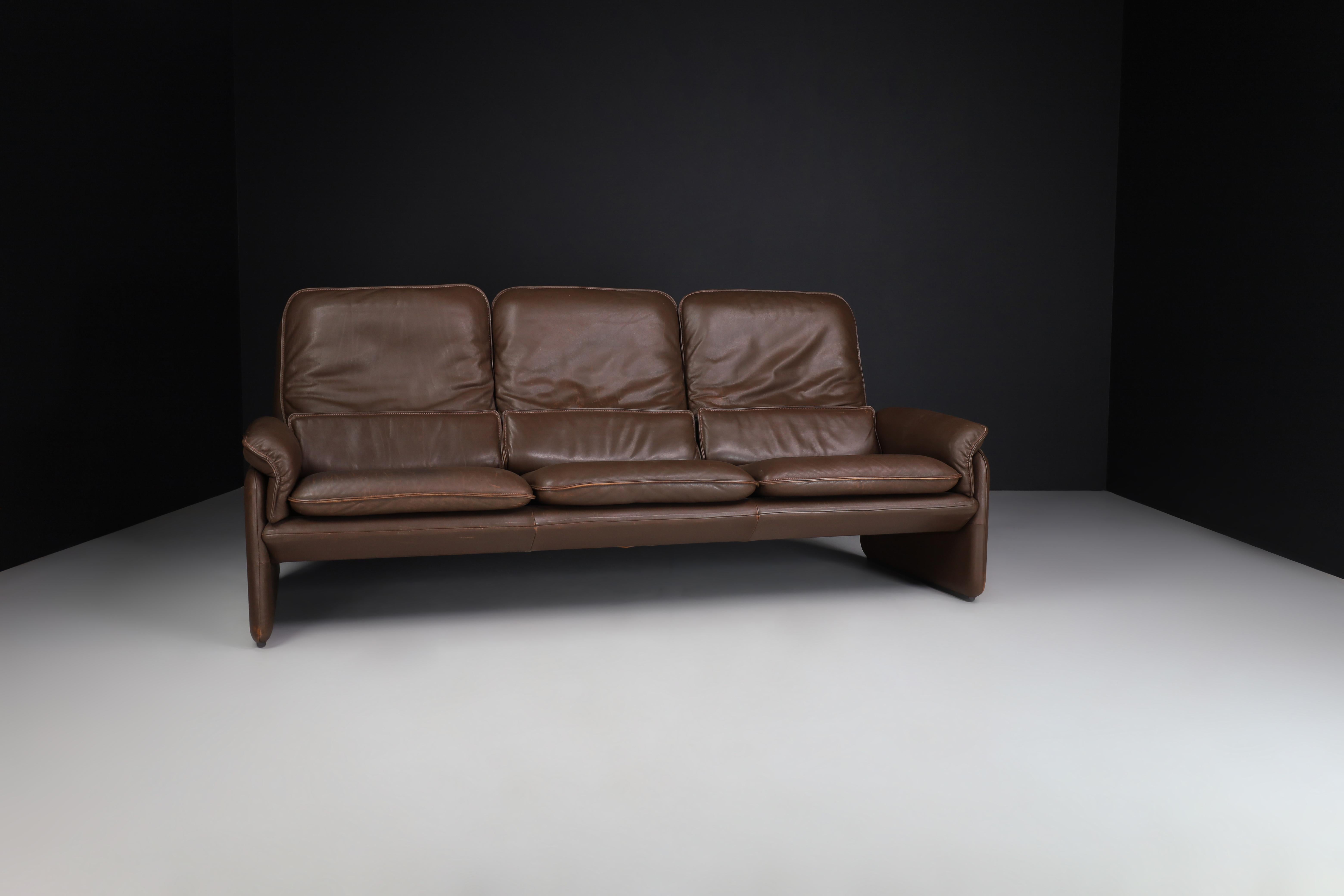 Beautiful DS-61 in coffee brown leather sofa by 'De Sede' Switzerland from the 1970s with a lovely patina in good allover condition. This lounge sofa supports tremendous and is an absolute eye-catcher in your interior. De Sede started as a family