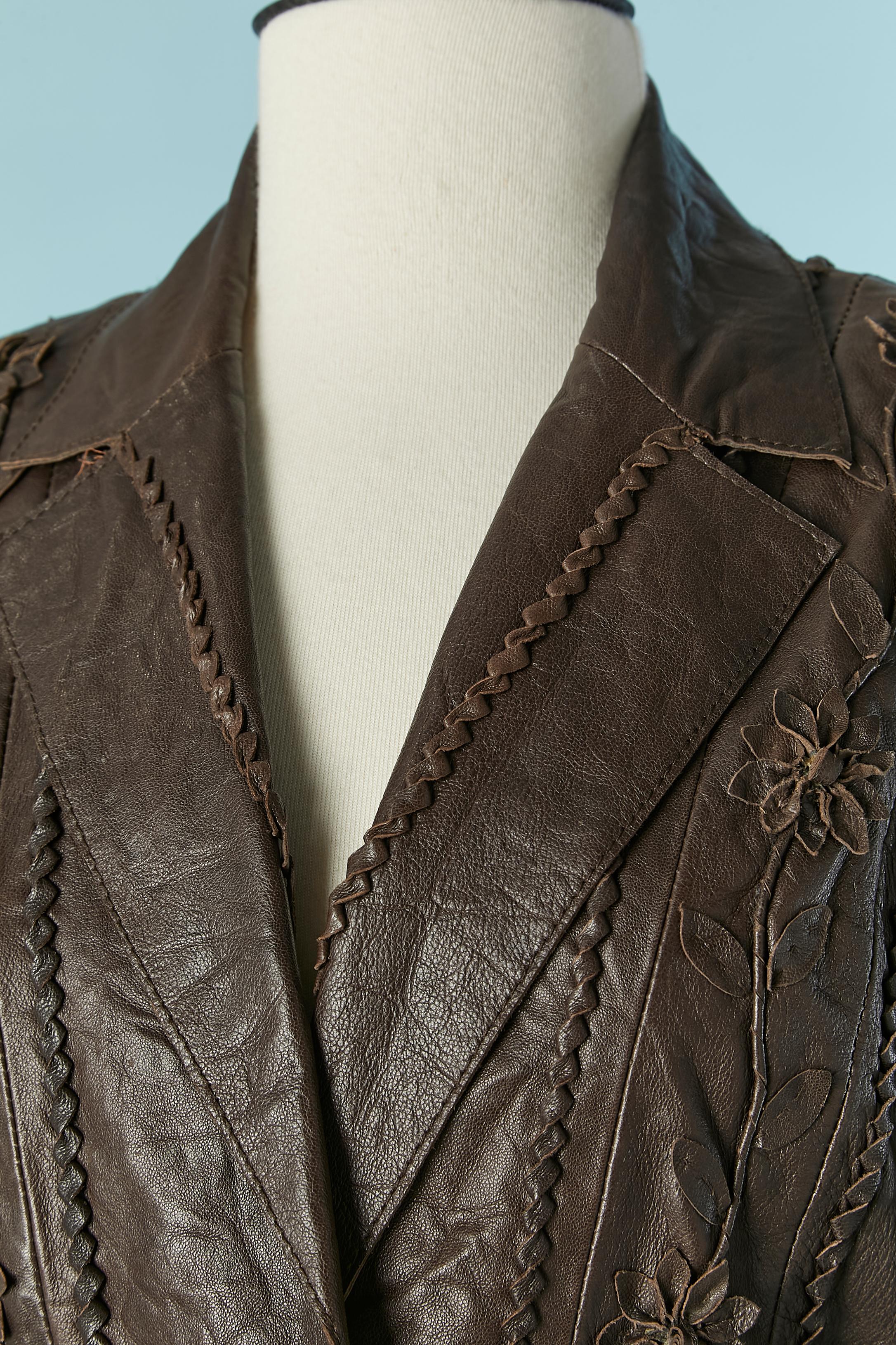 Brown leather jacket with leather flower appliqué. Cotton lining. Carved button. Shoulder pad. Leather laces on the middle back with eyelet. Authenticity hologram. Top-stitched.
SIZE 42 (It) 38 (Fr) M 